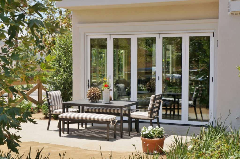 A patio with a table and chairs in front of a house
