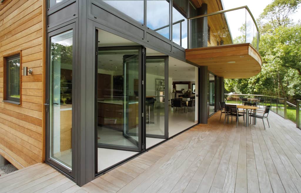 A large house with a large deck and lots of windows