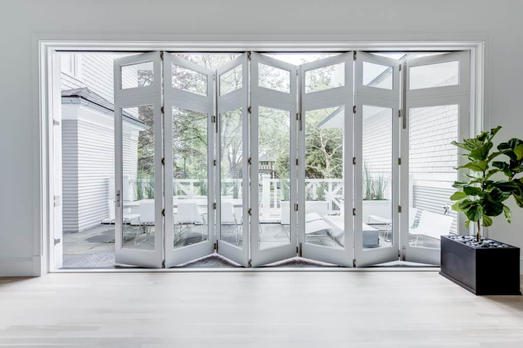 A living room with a large window and a plant in front of it.