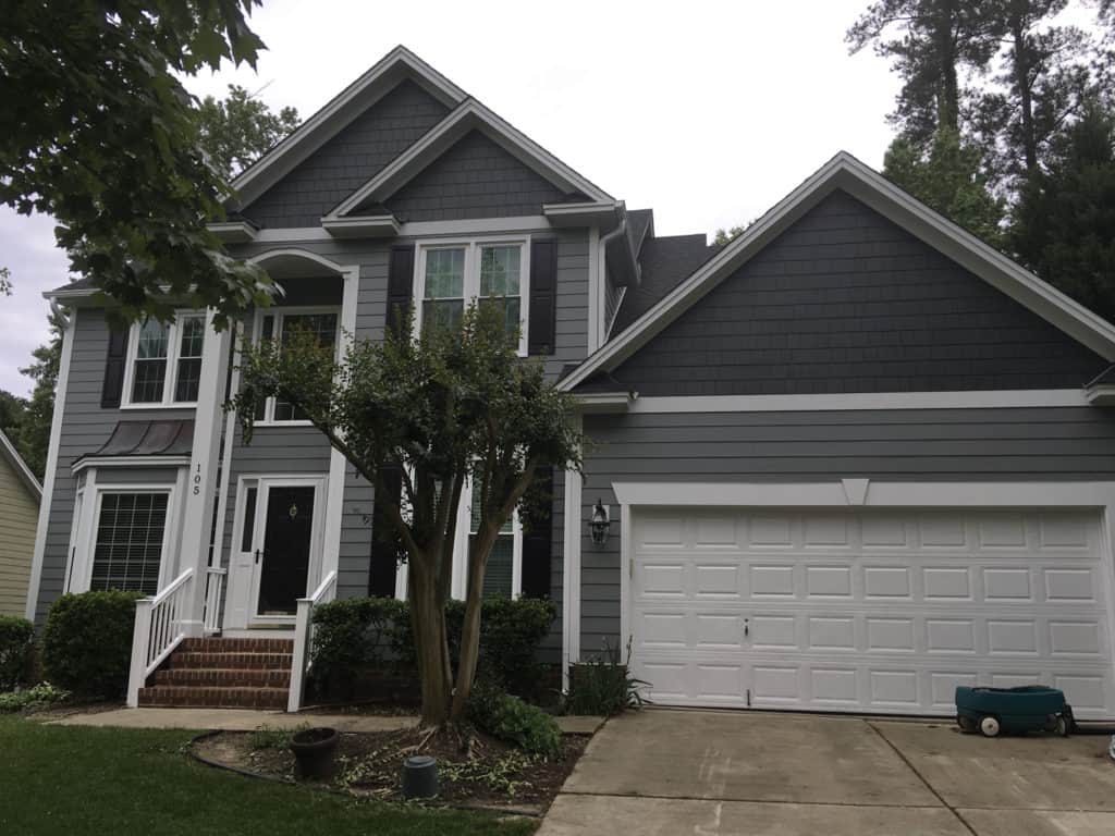 A large gray house with a white garage door