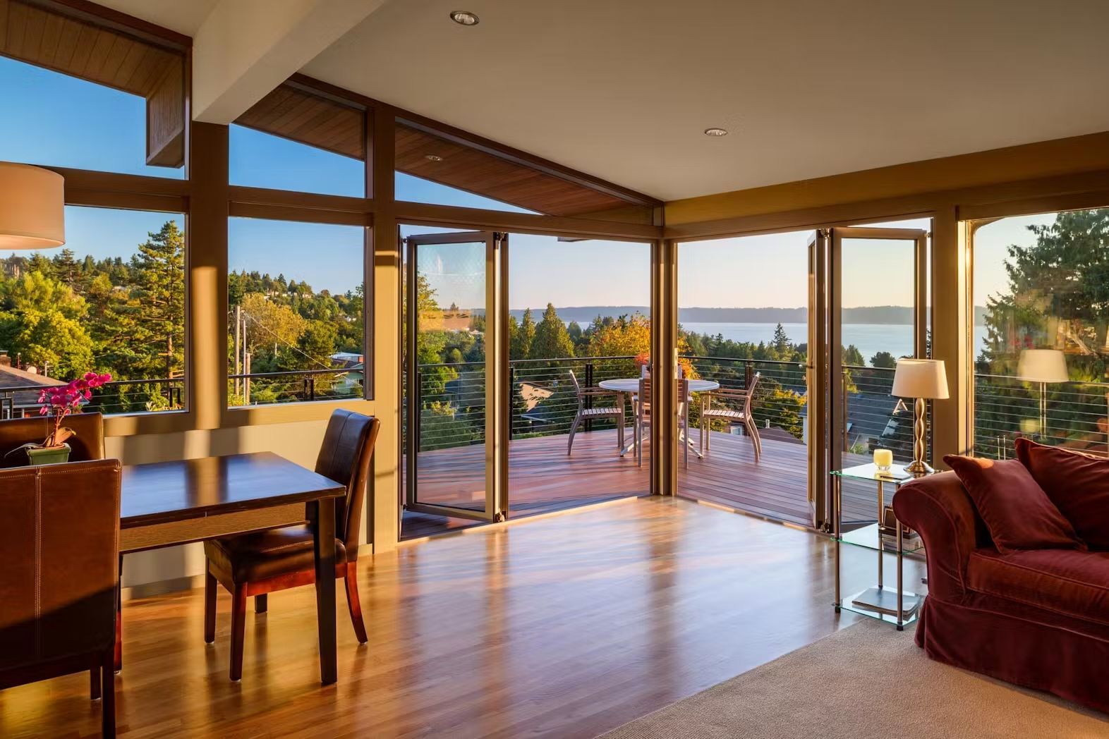 A living room with a table and chairs and a view of the ocean