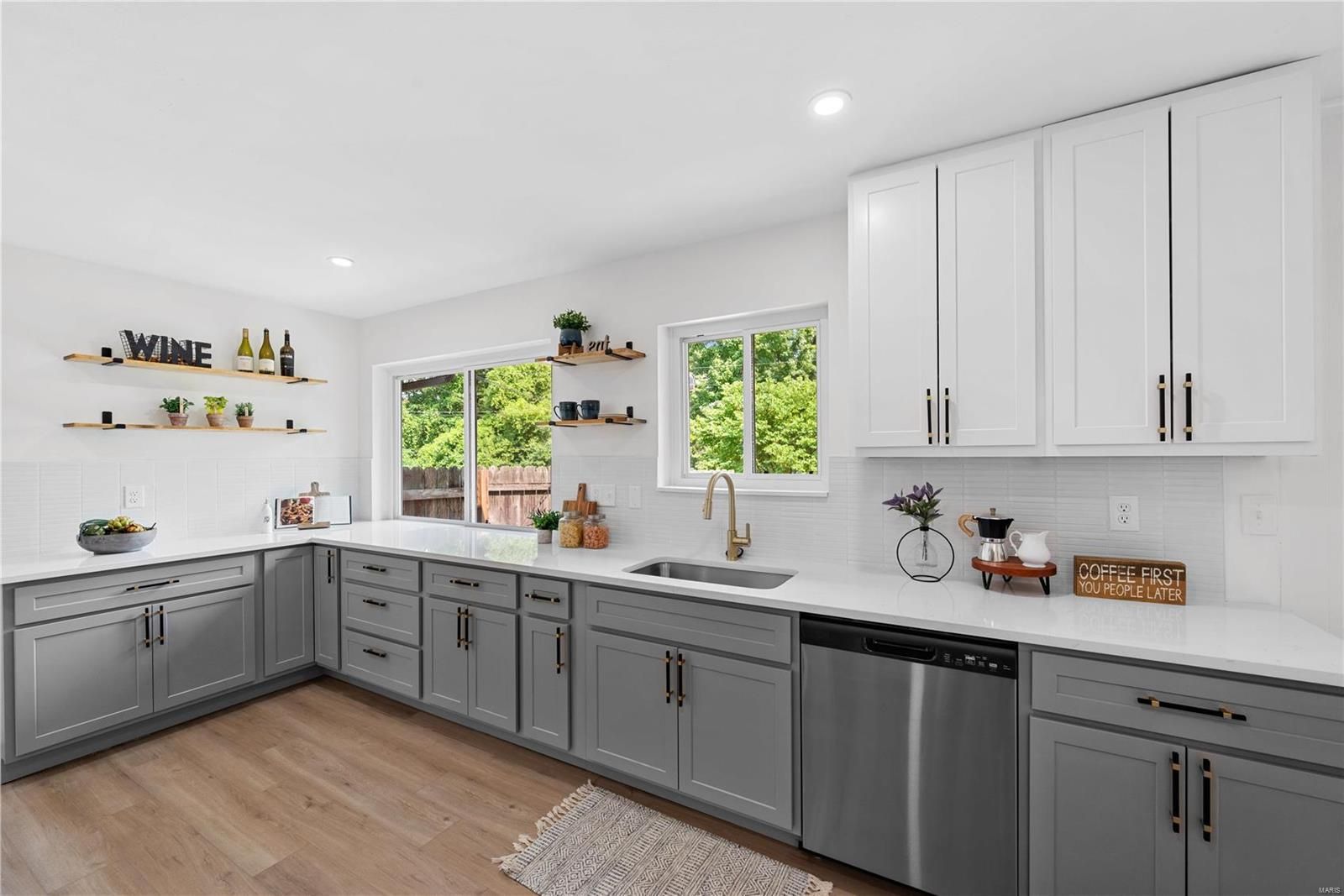 A kitchen with blue cabinets and white cabinets and a large island in the middle.