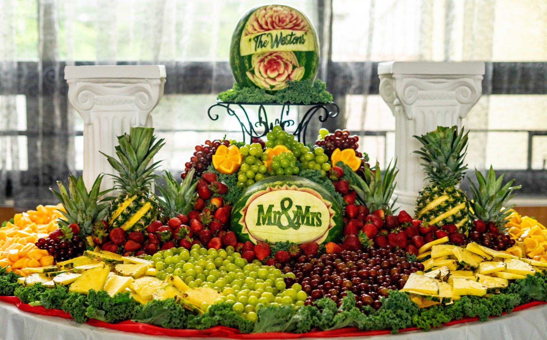 A fruit display with a watermelon carved into it that says mr. and mrs.