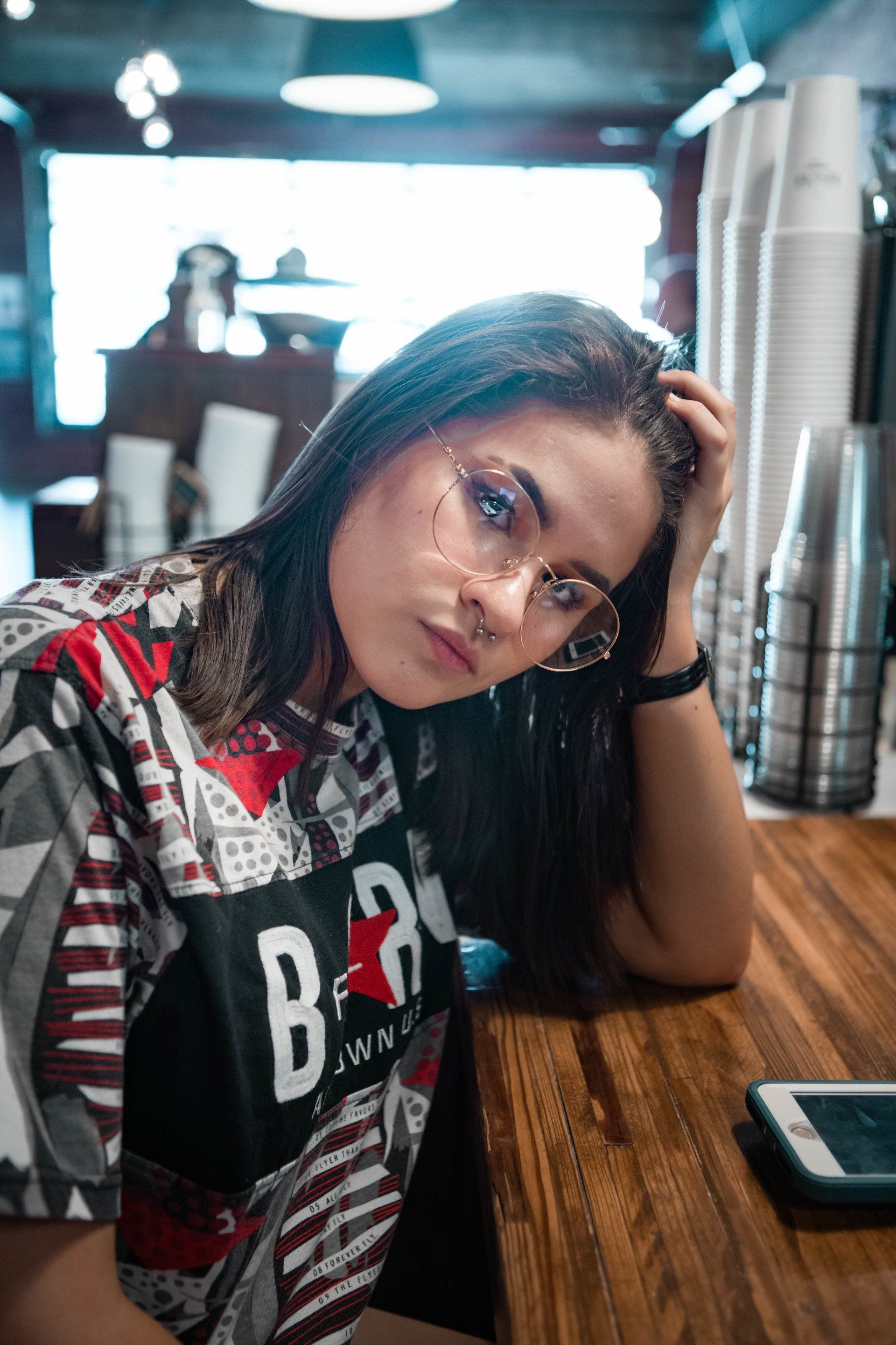 A woman wearing glasses is sitting at a table in a restaurant.