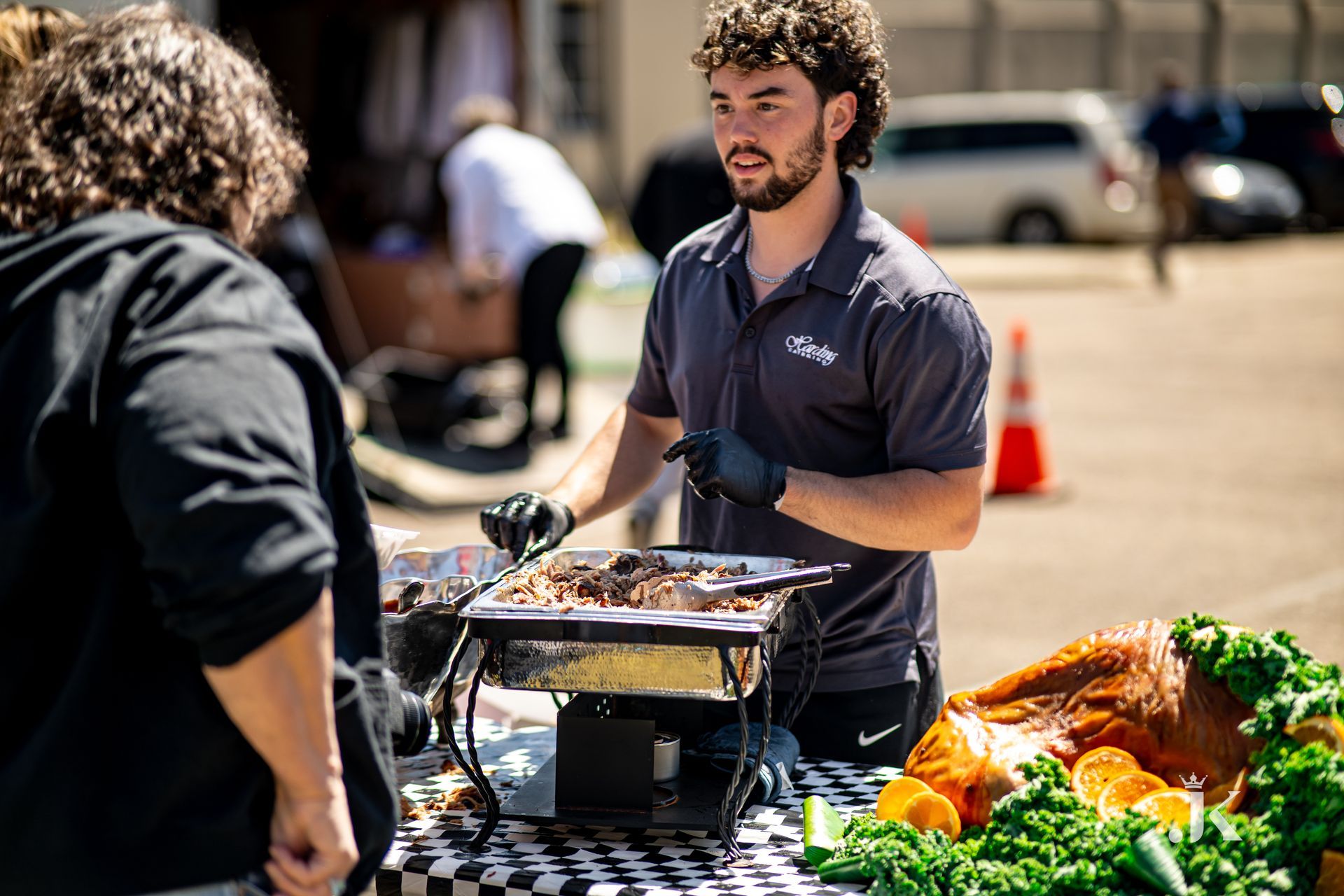 A man is standing at a table serving food to a woman.