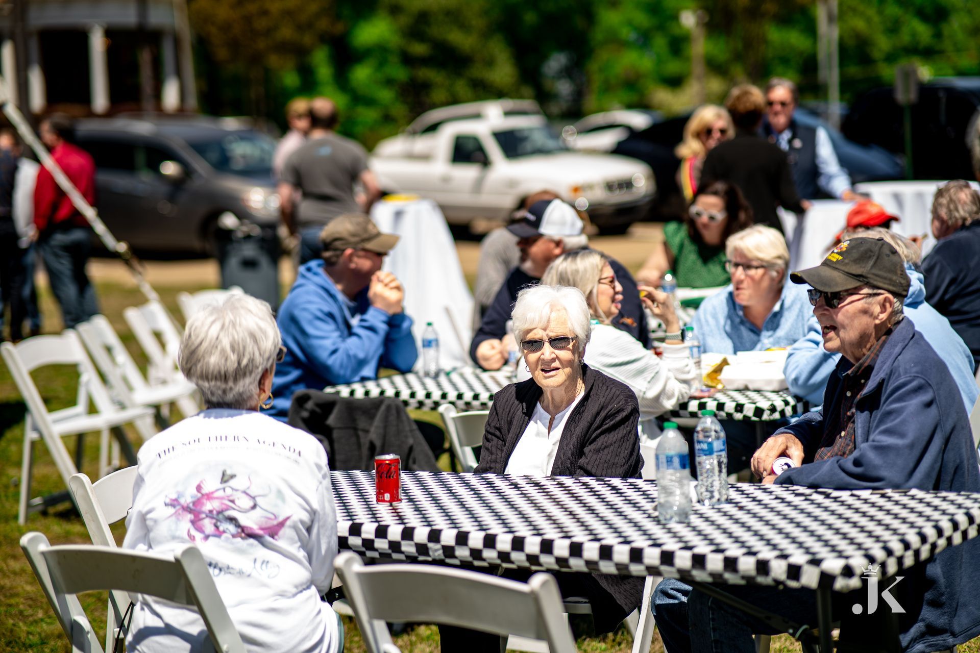 A group of people are sitting at tables outside.