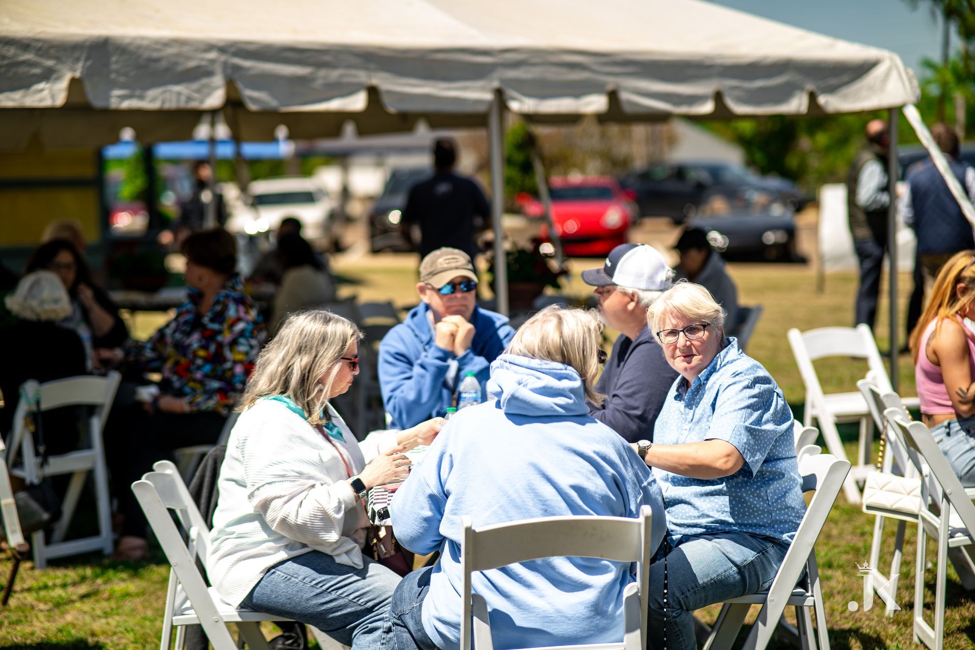 A group of people are sitting around a table under a tent.