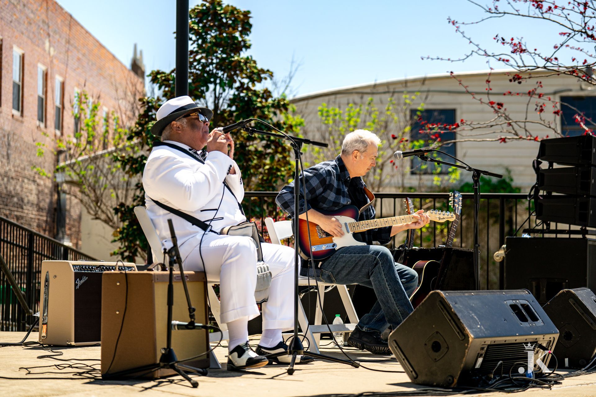Two men are playing guitars and singing on a stage.