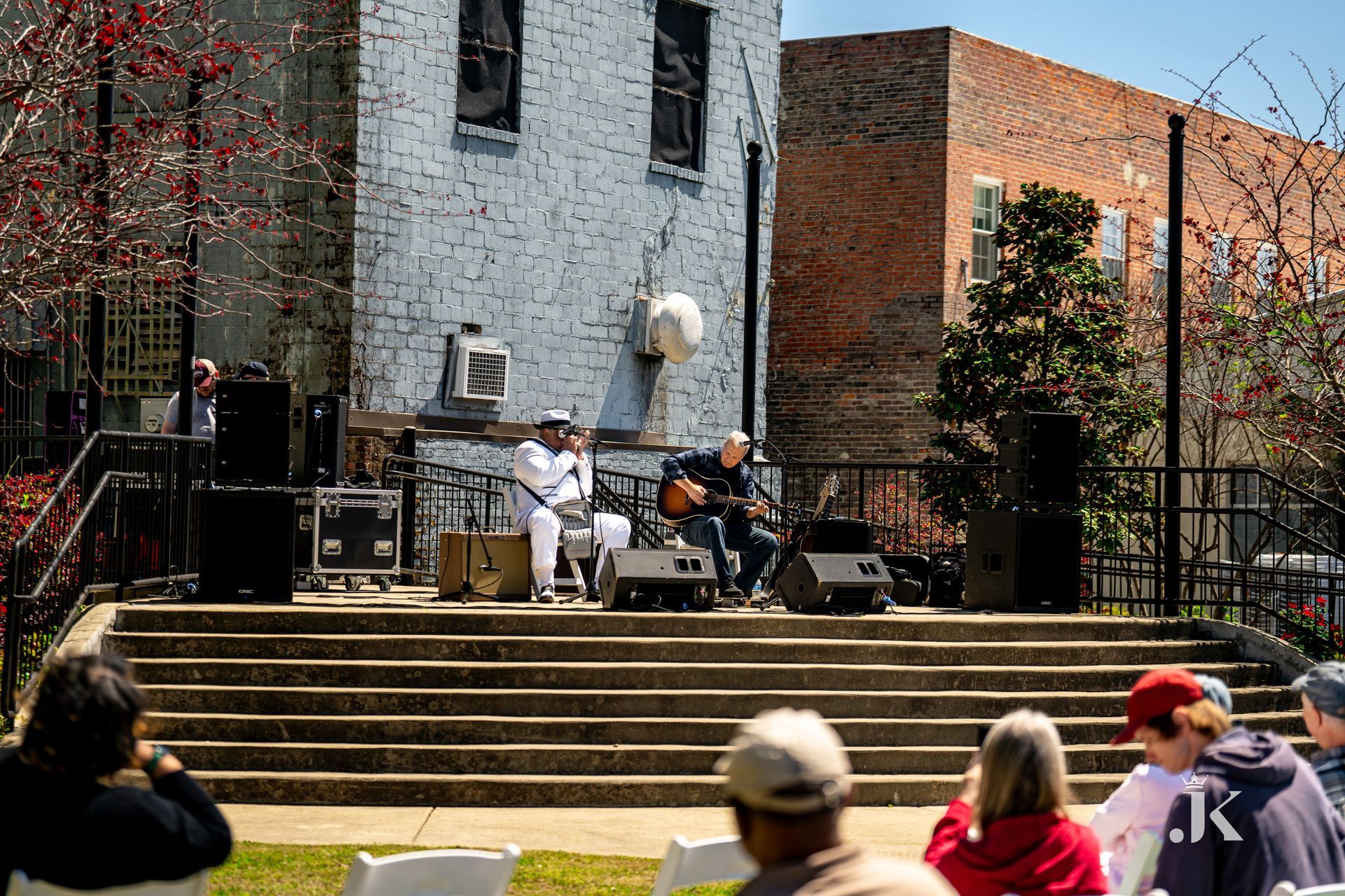 A man is playing a guitar on a stage in front of a crowd of people.
