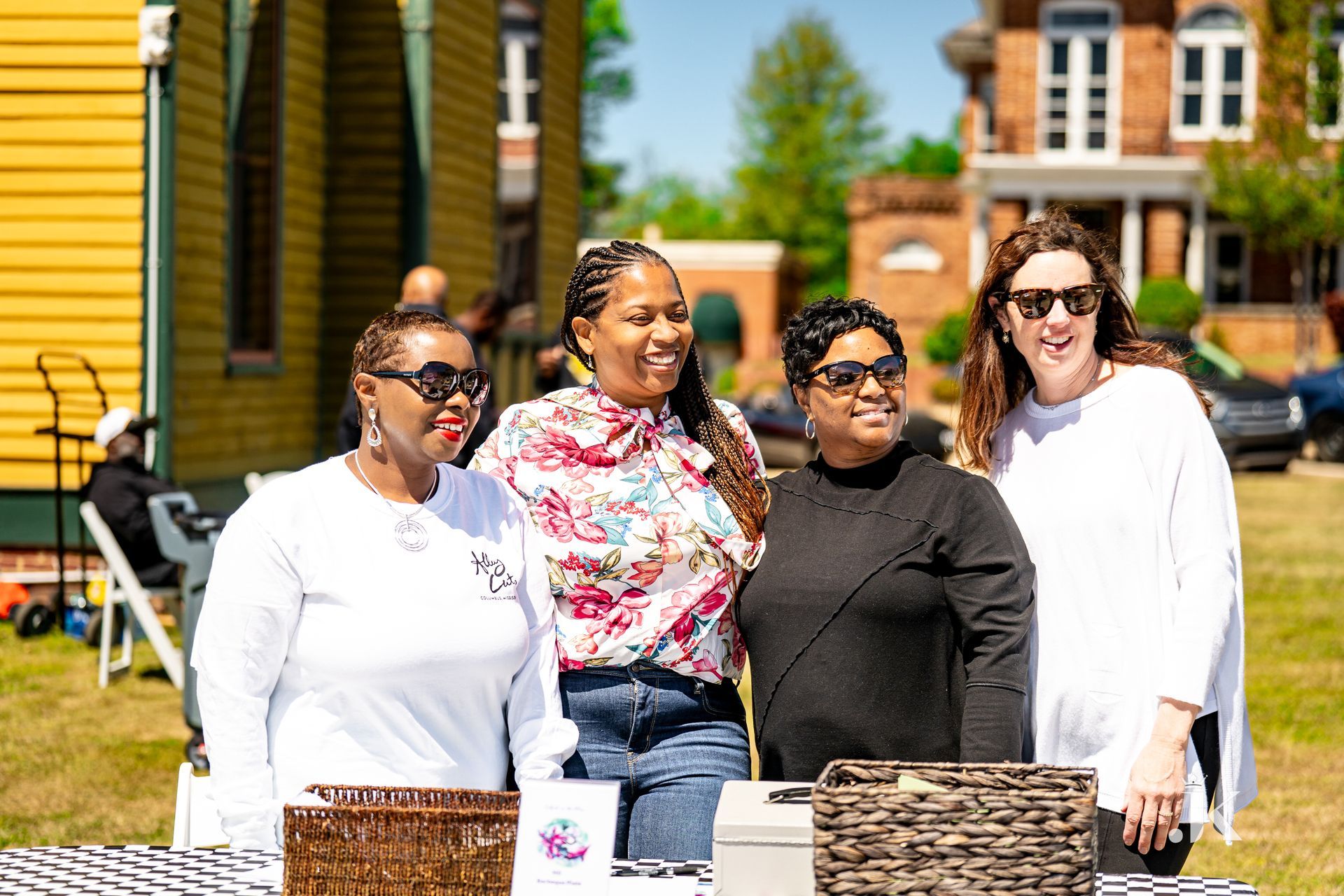 A group of women are posing for a picture in front of a table.
