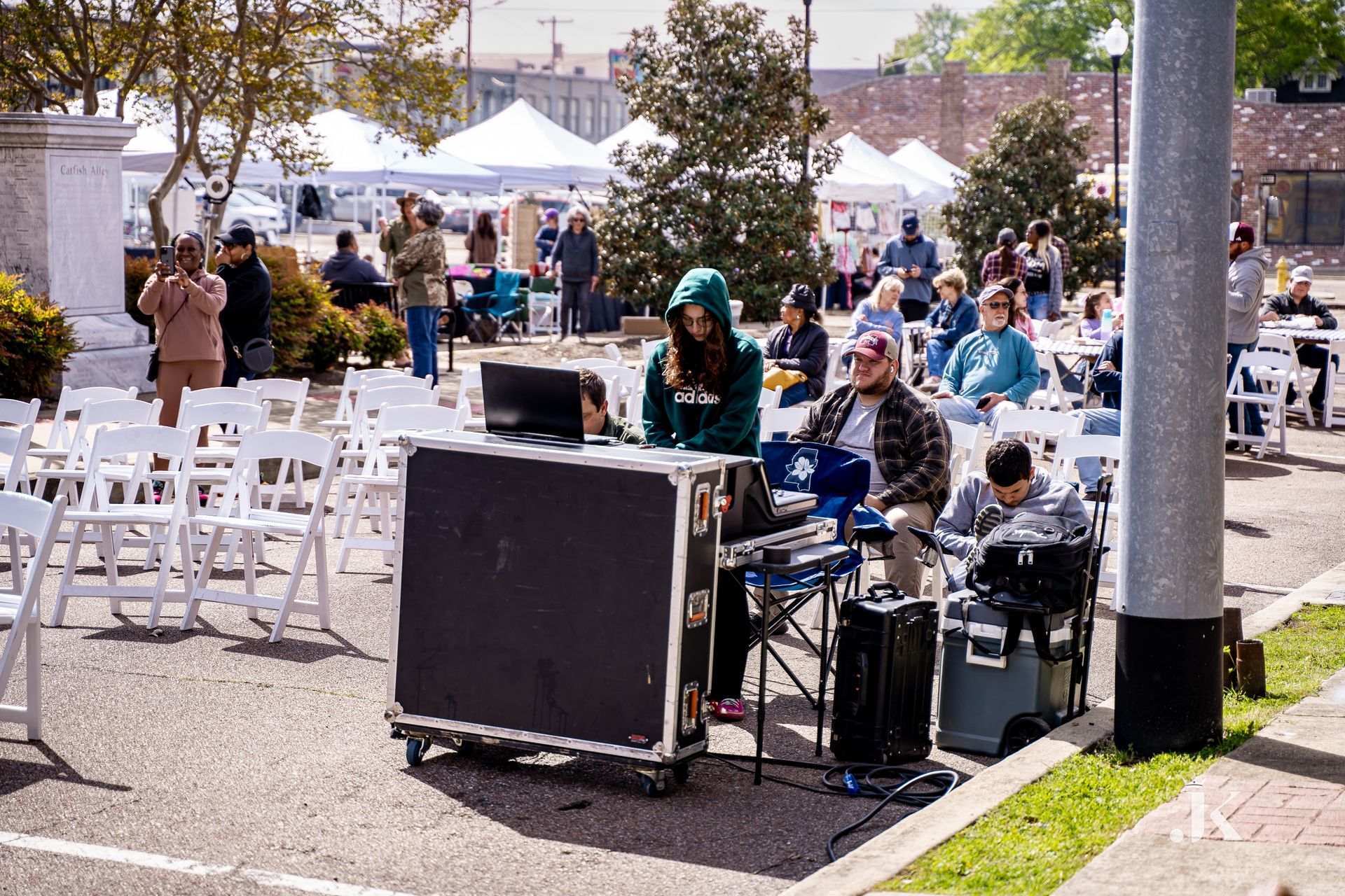 A group of people are sitting at tables in a park.