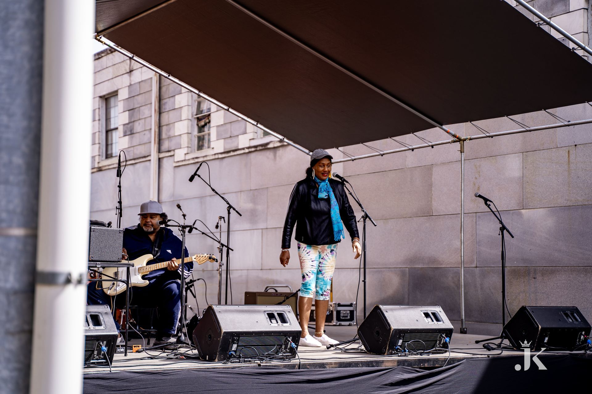 A man playing a guitar and a woman singing on a stage