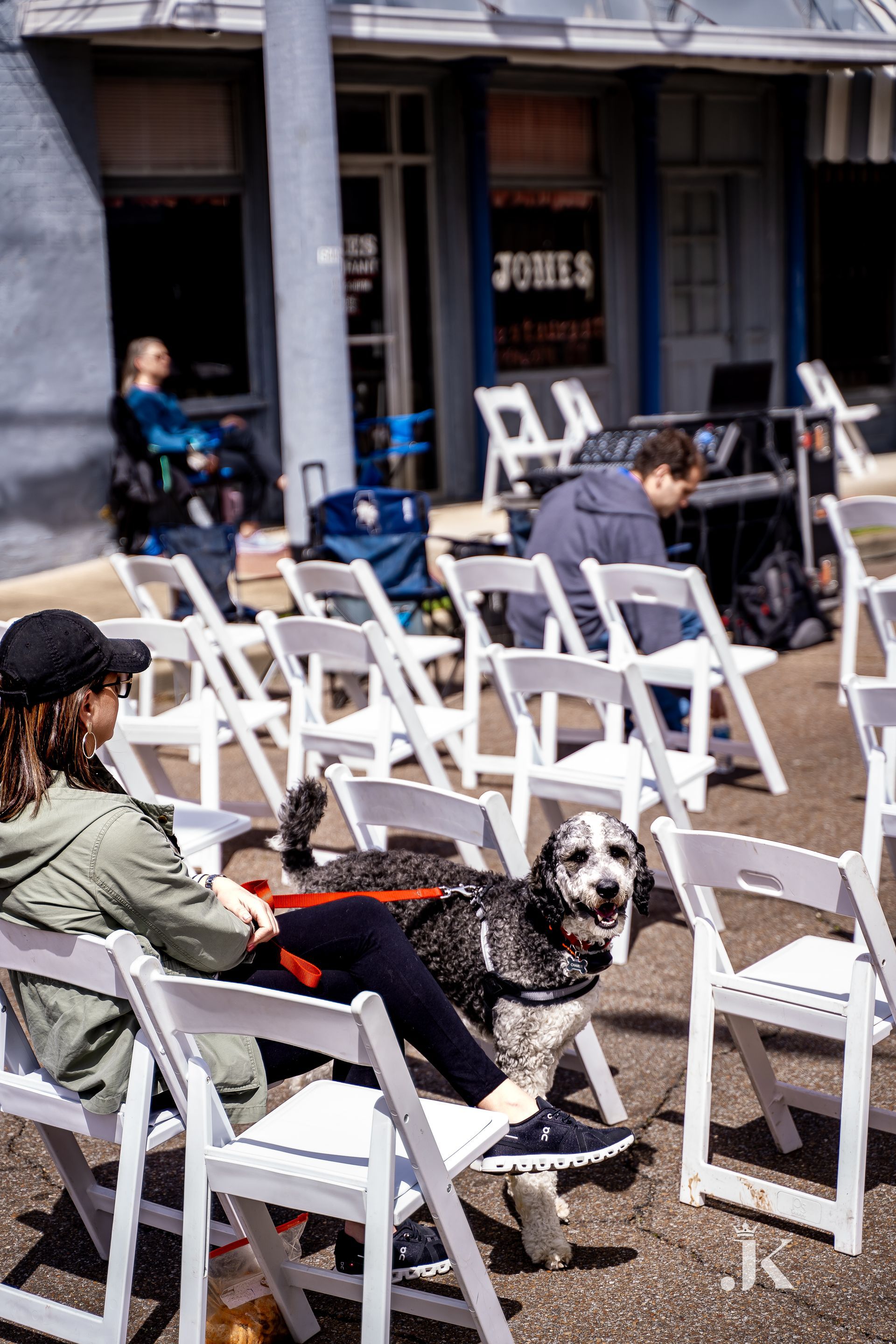 A woman is sitting in a chair with a dog on her lap.
