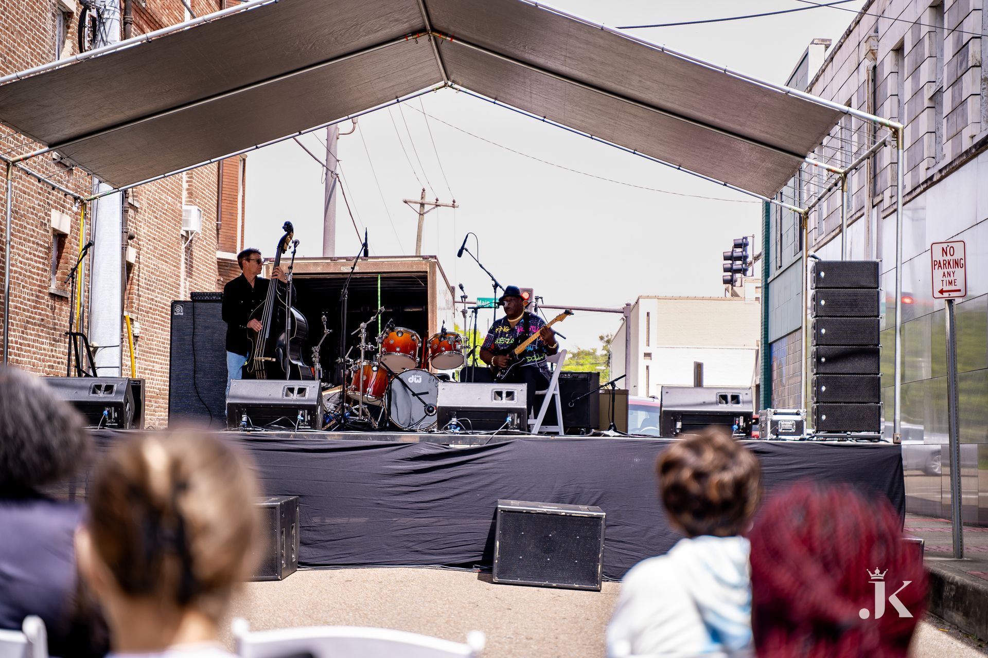 A group of people are sitting in front of a stage with a band on it.