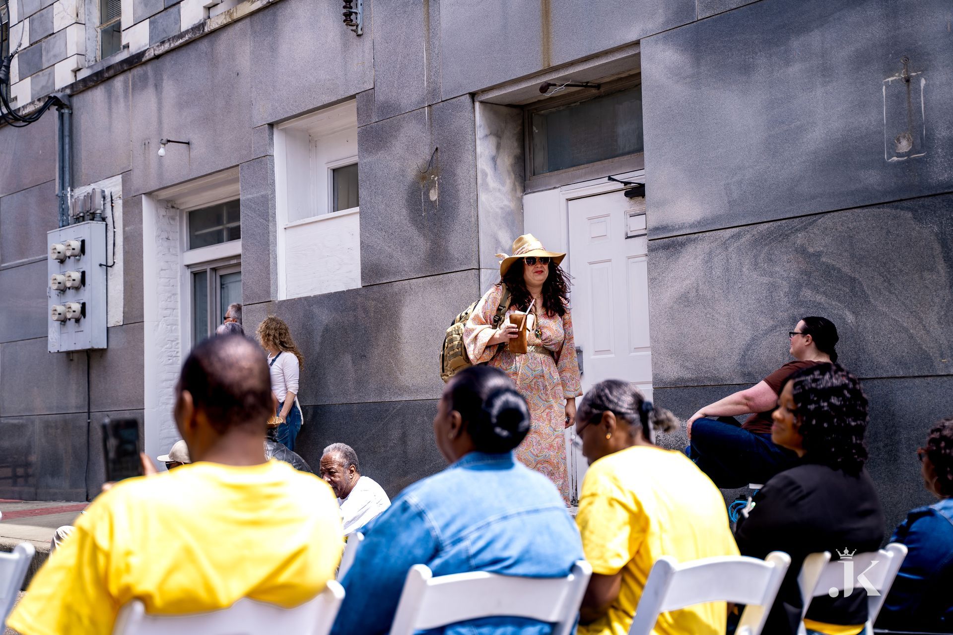 A woman in a cowboy hat stands in front of a group of people