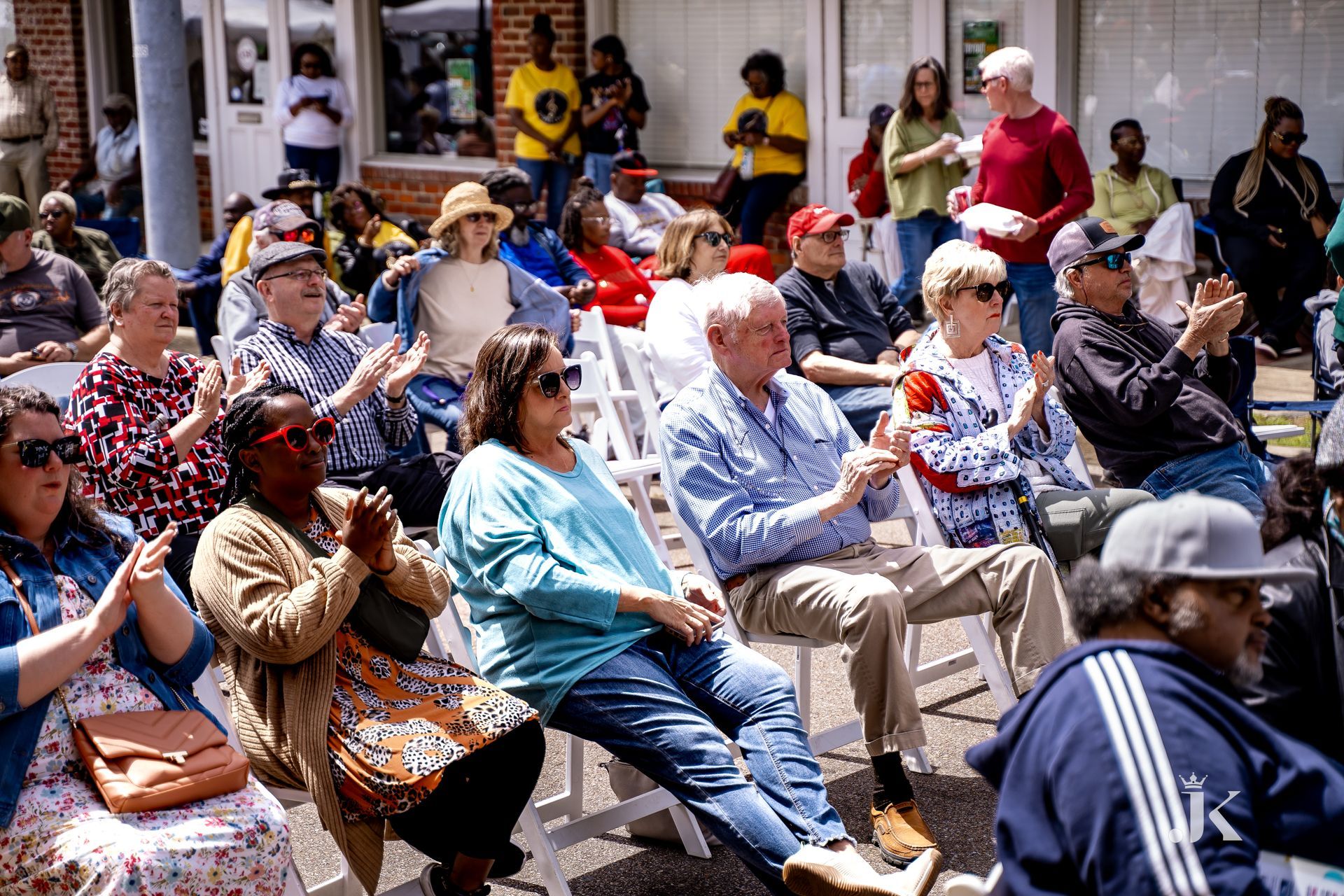 A group of people are sitting in chairs watching a parade.
