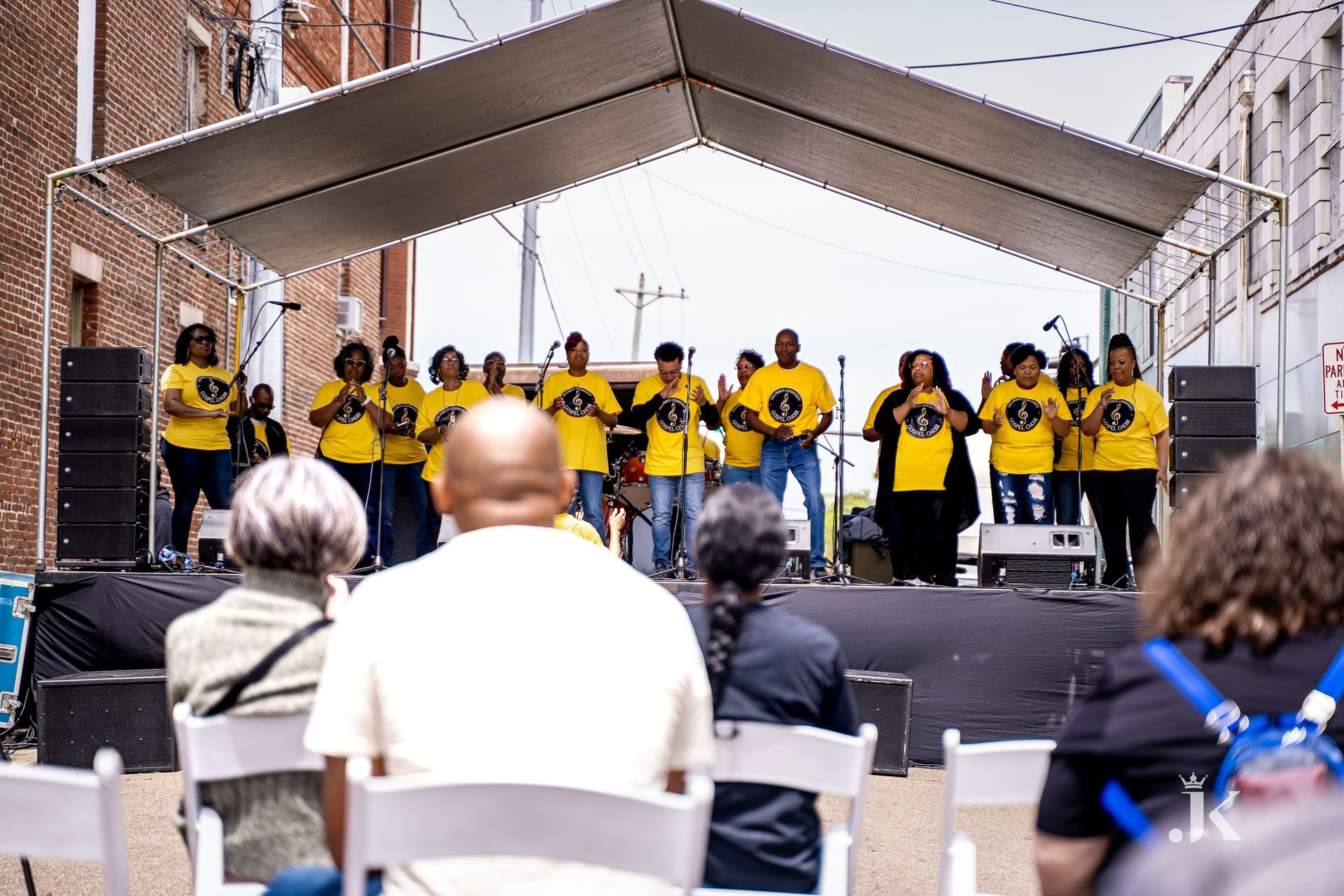 A group of people are singing on a stage in front of a crowd.
