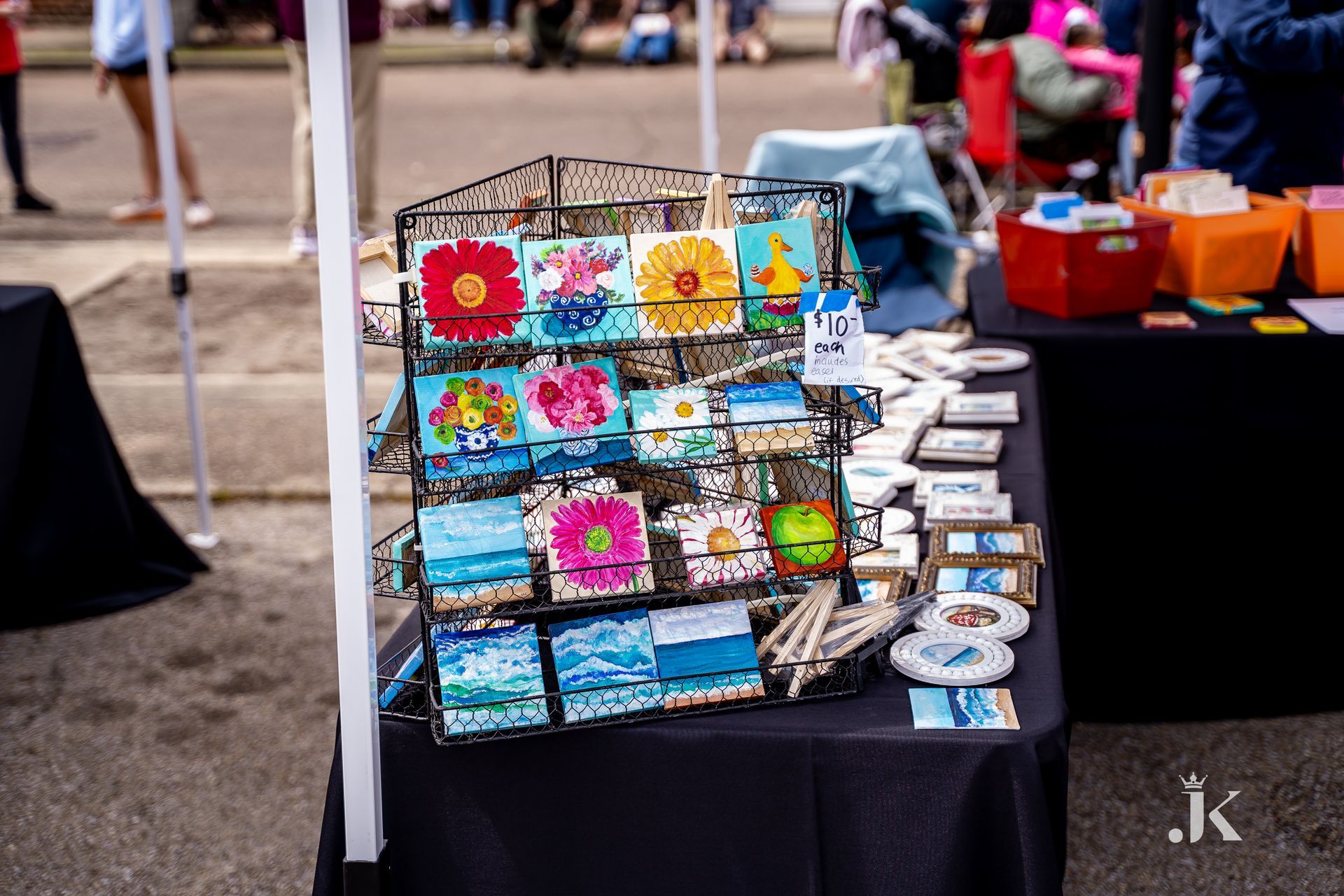 A table with a display of paintings and coasters on it.