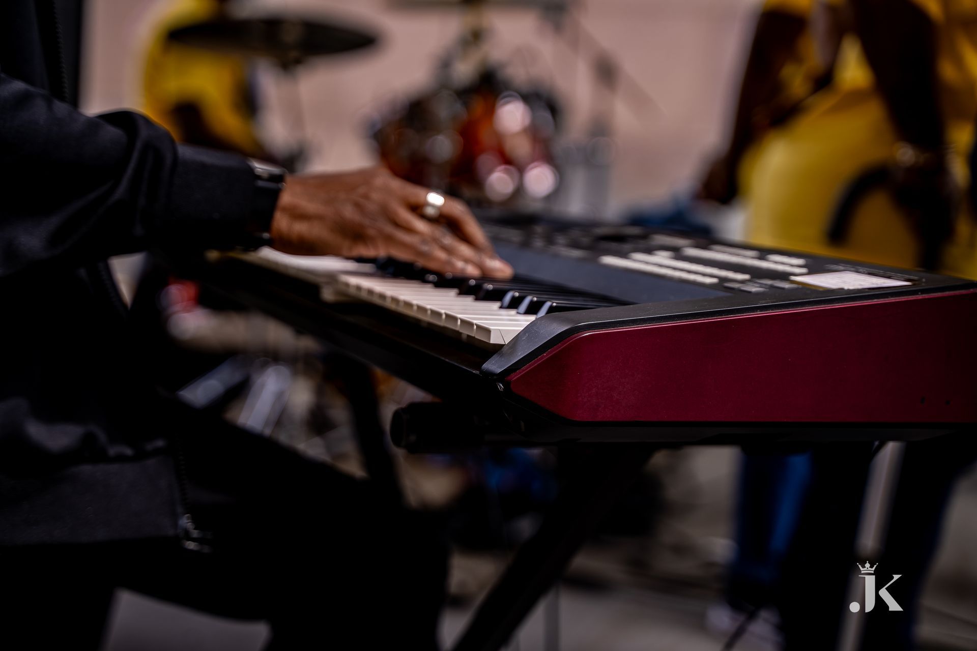 A person is playing a keyboard with a ring on their finger.