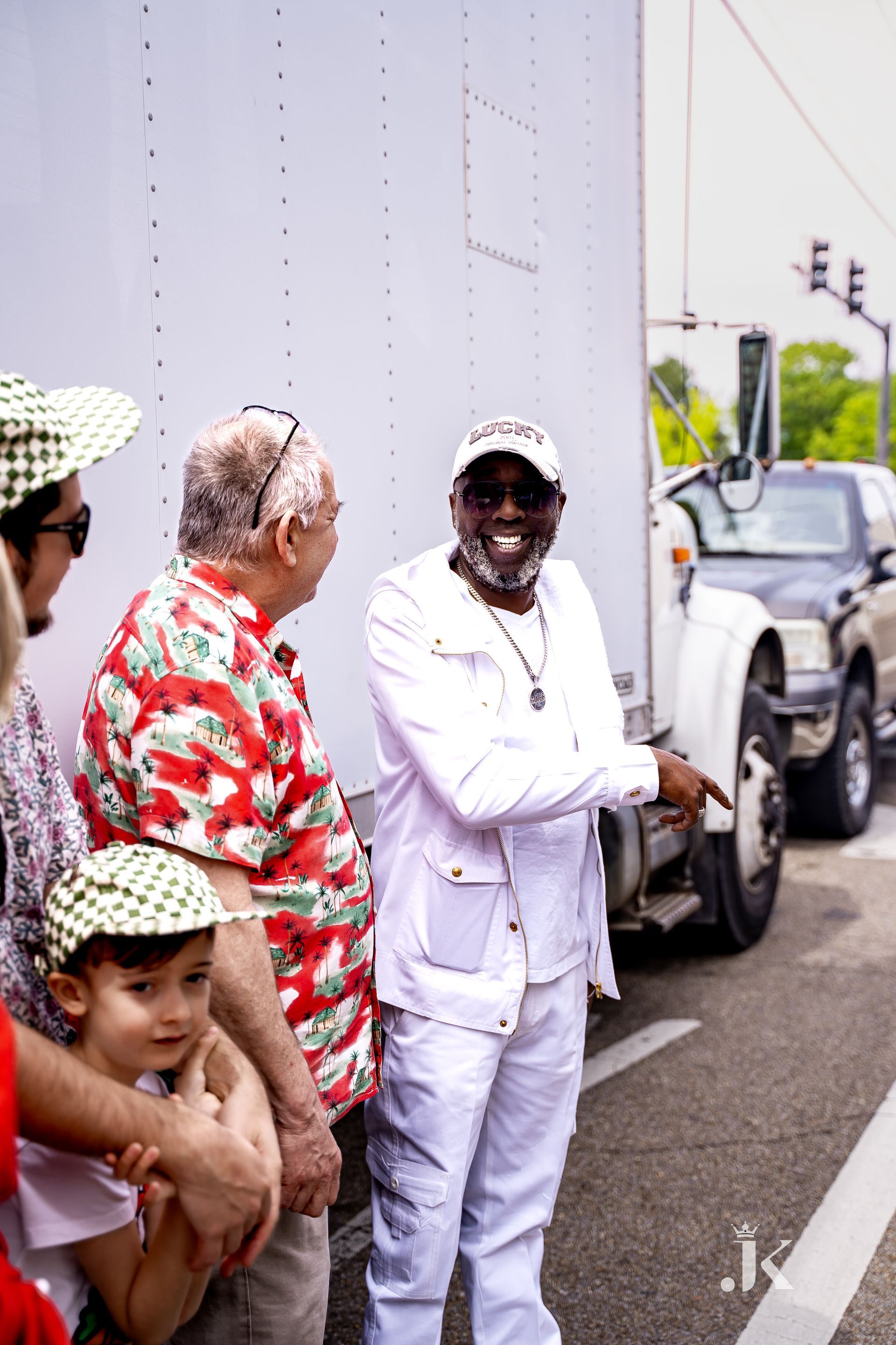A group of people are standing in front of a white truck.