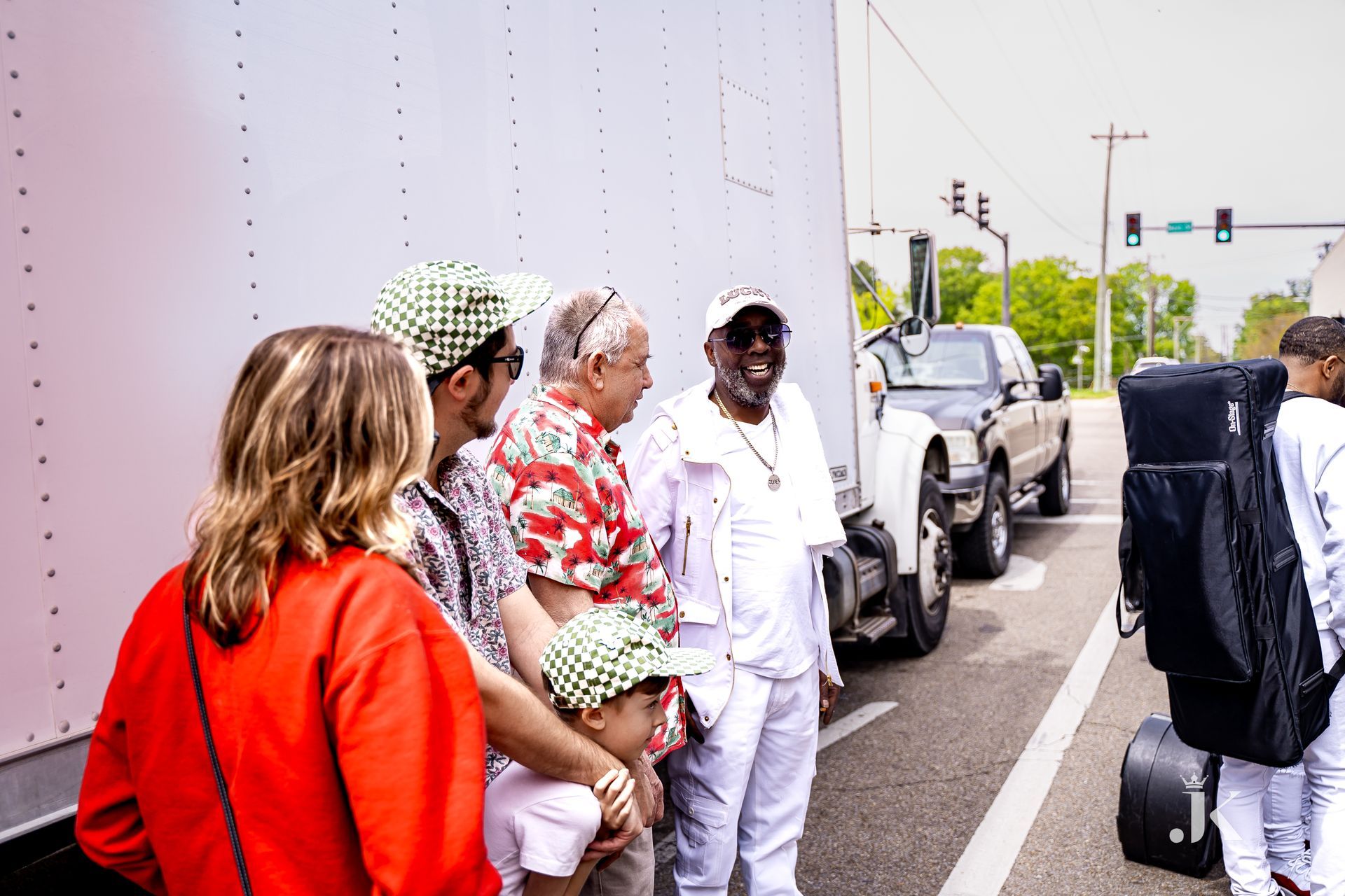 A group of people are standing next to a truck on the side of the road.