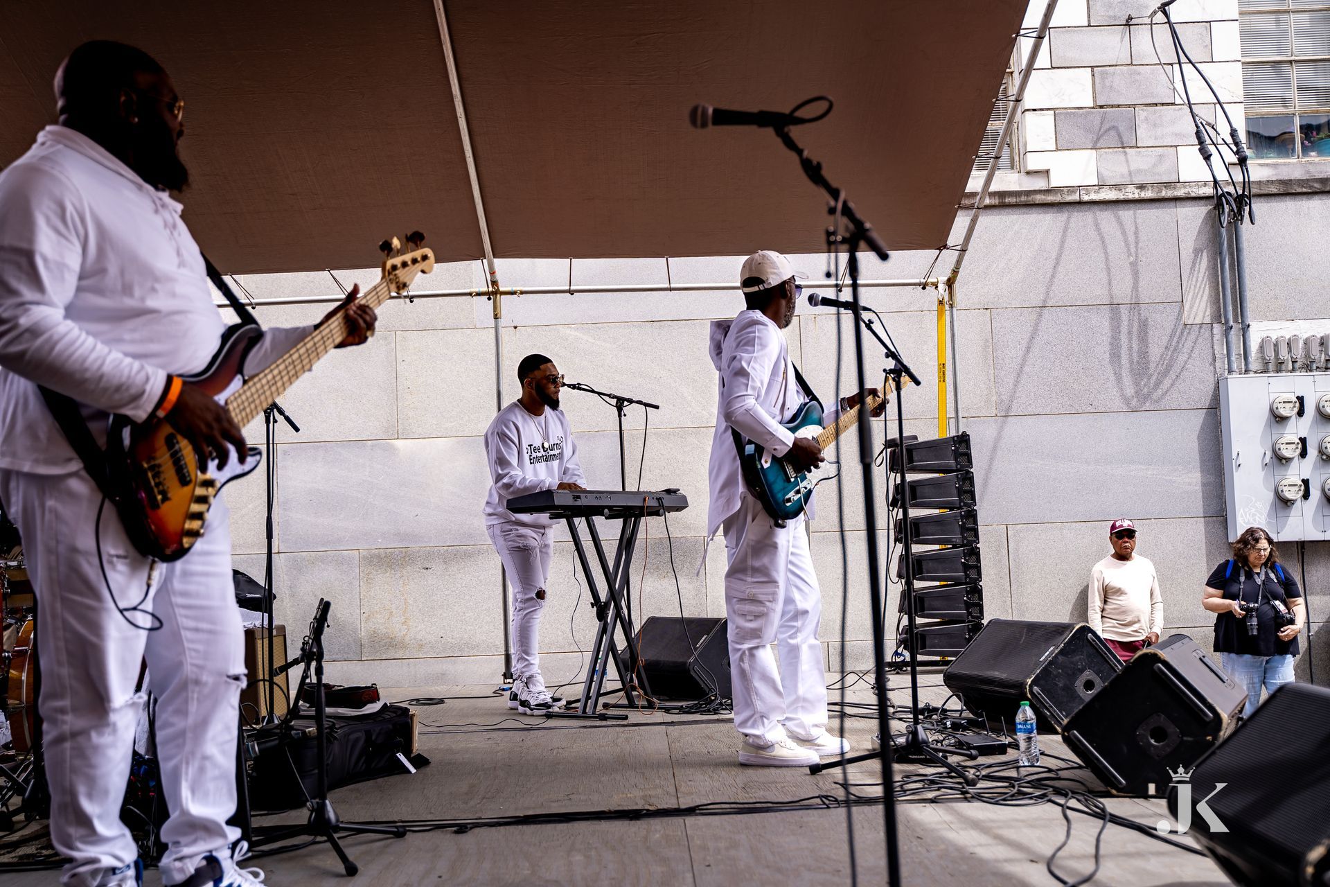 A group of men playing guitars and keyboards on a stage