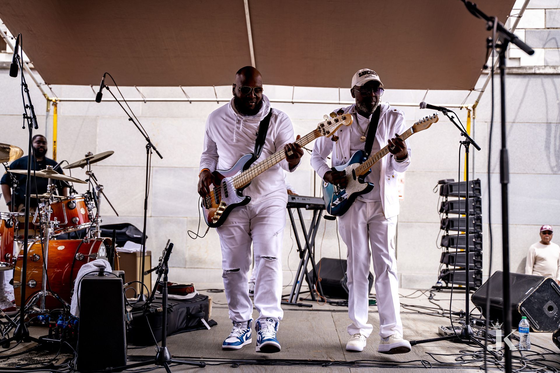 Two men are playing guitars on a stage.