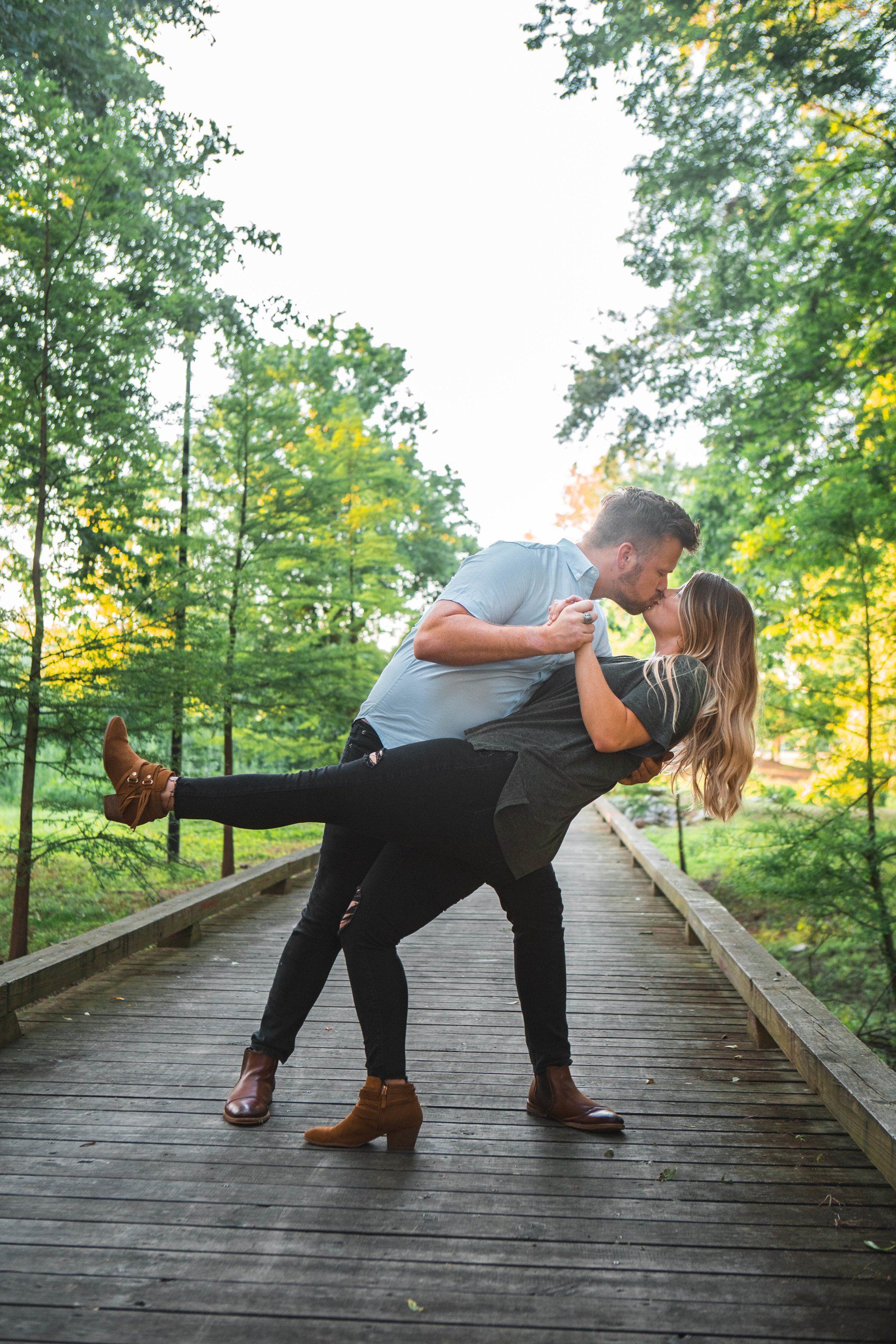 A man is holding a woman in his arms and kissing her.