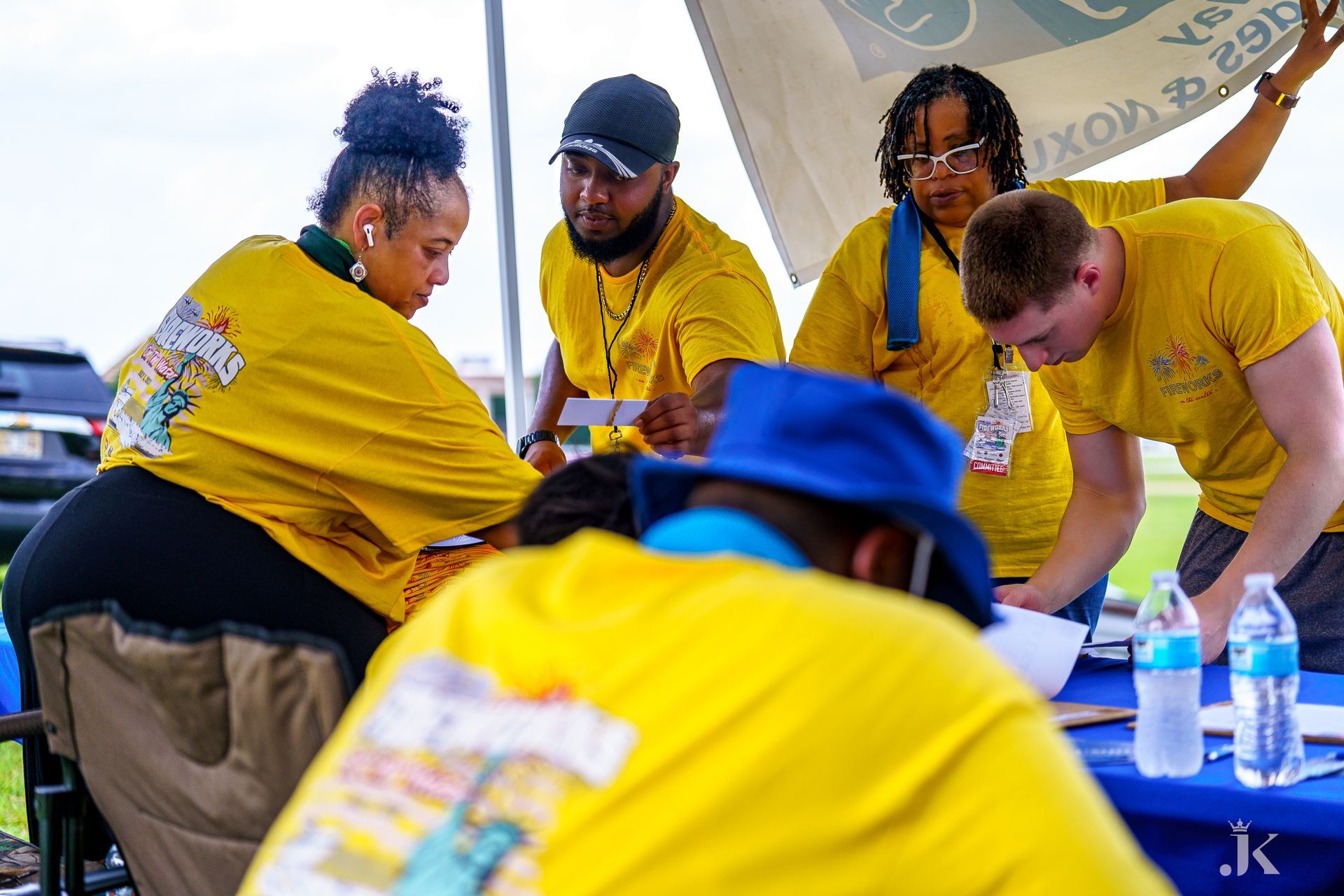 A group of people in yellow shirts are sitting around a table.