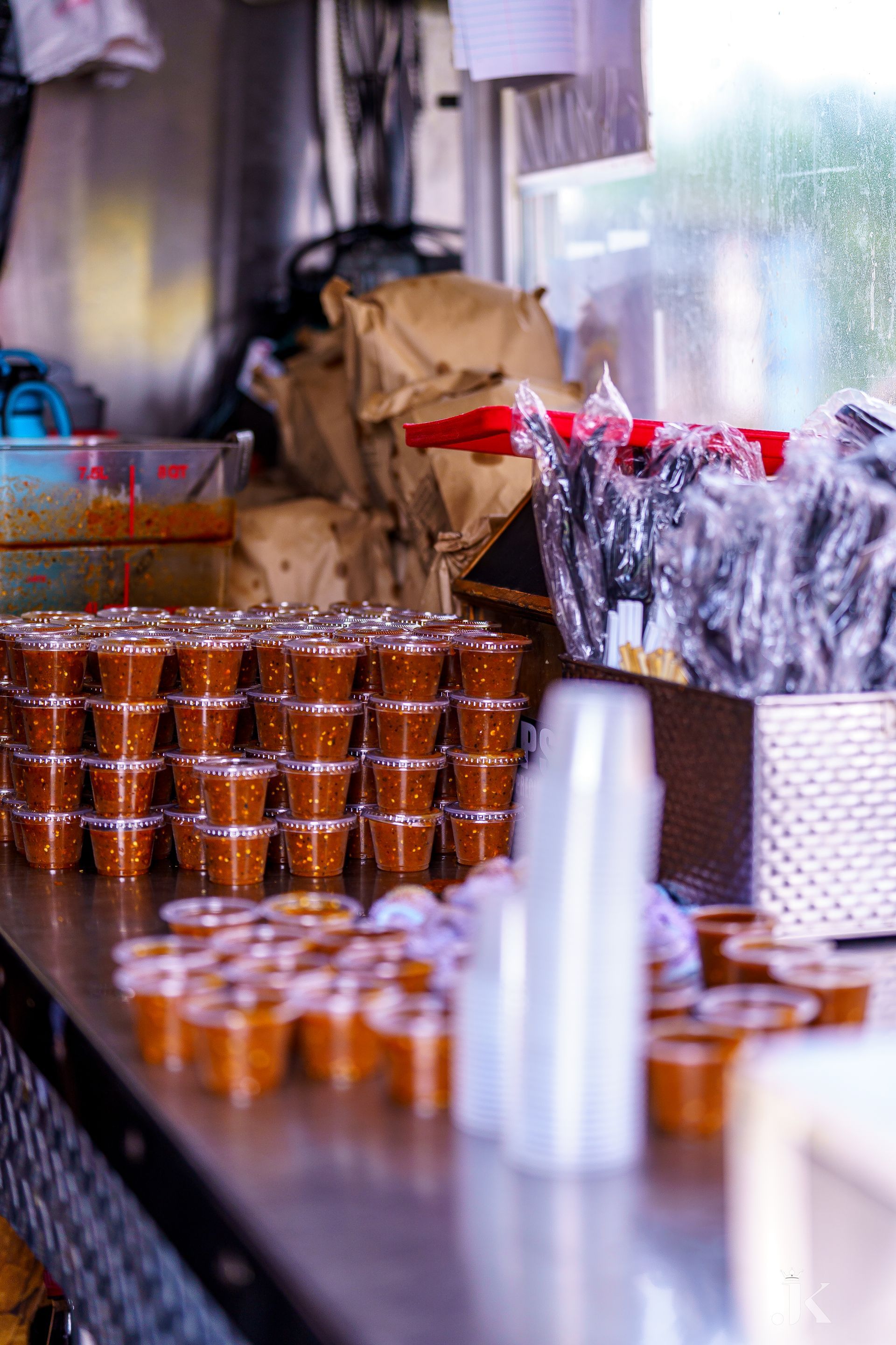 There are many cups of sauce on the table.