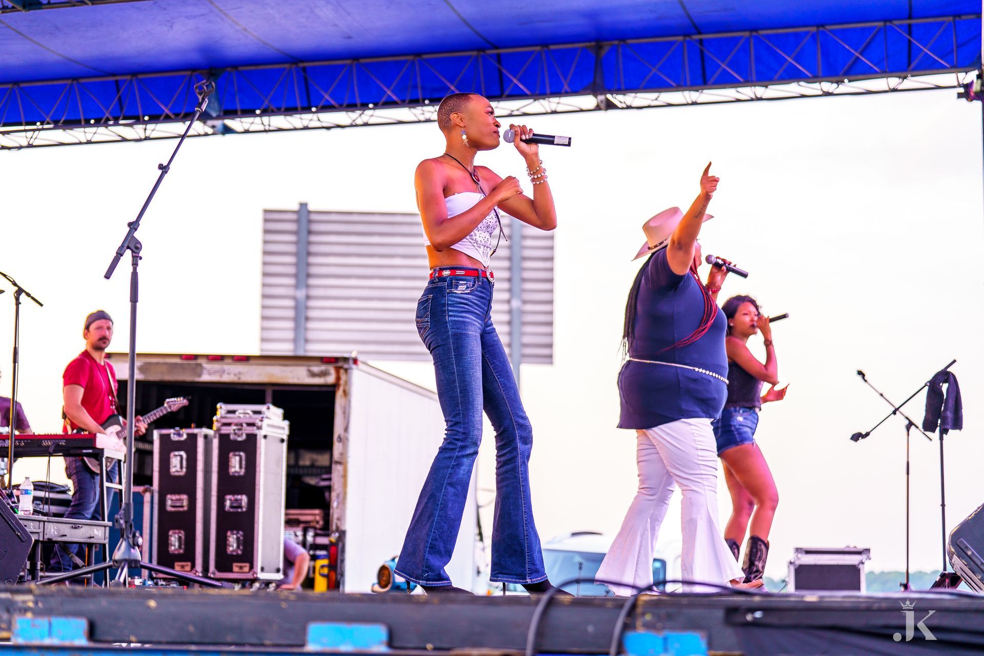 A group of people standing on a stage singing into microphones