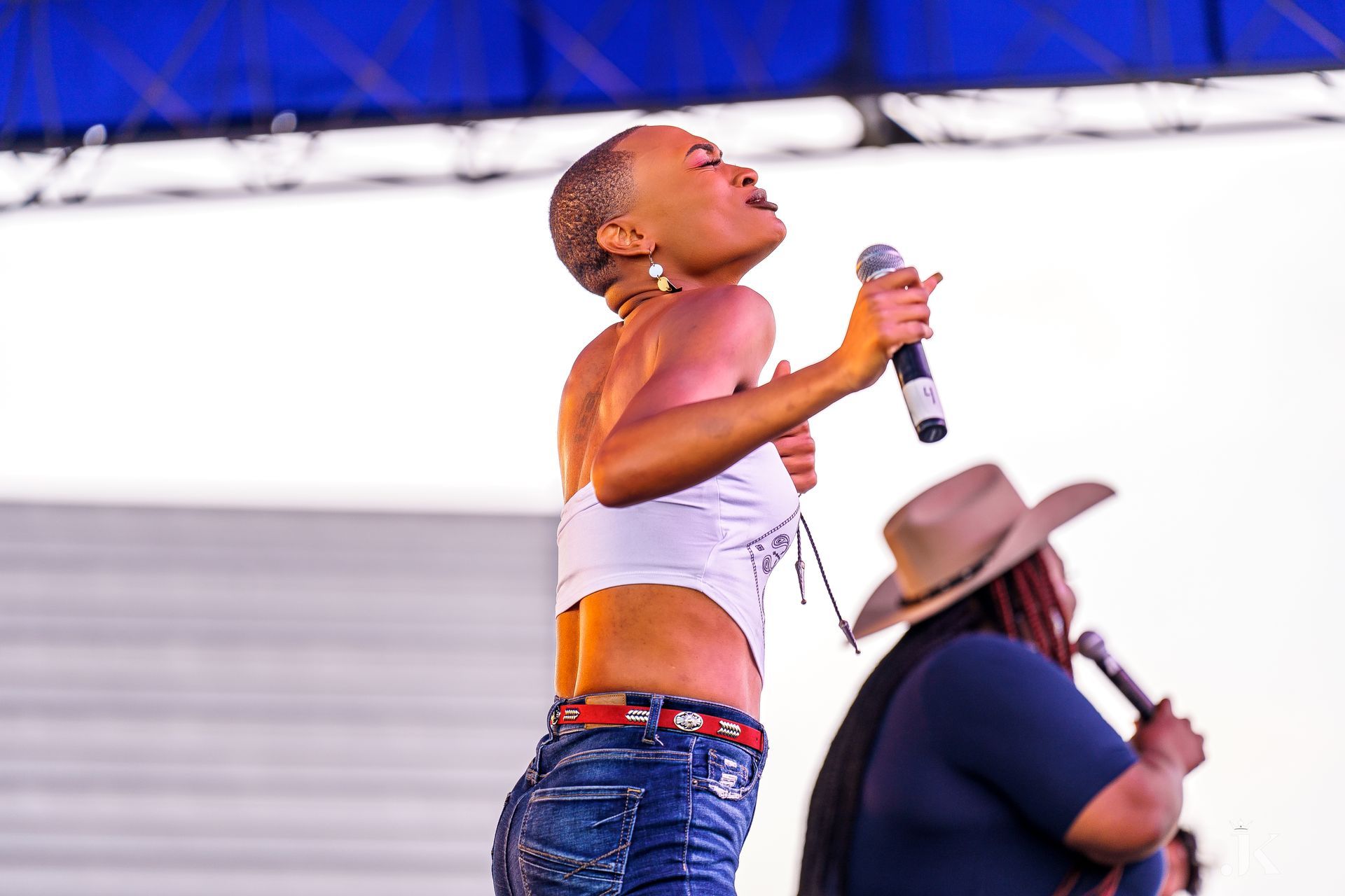 A woman is singing into a microphone on a stage.