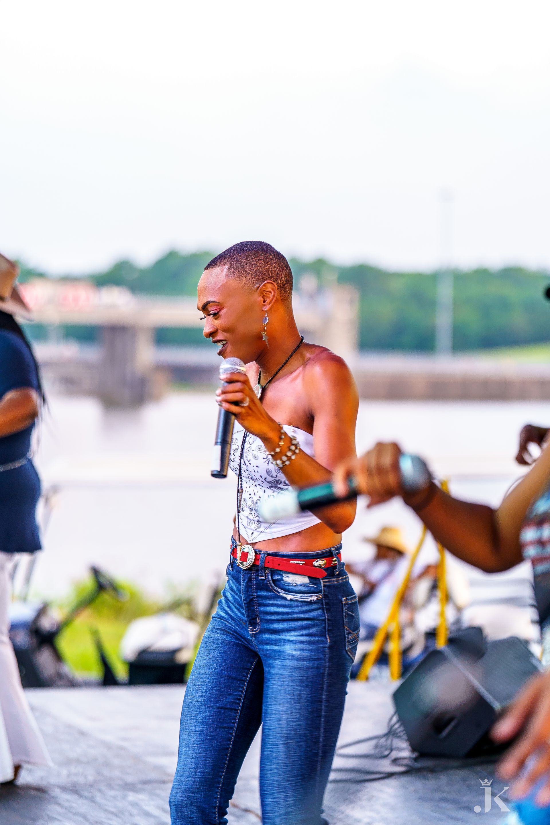 A woman is singing into a microphone while standing on a stage.