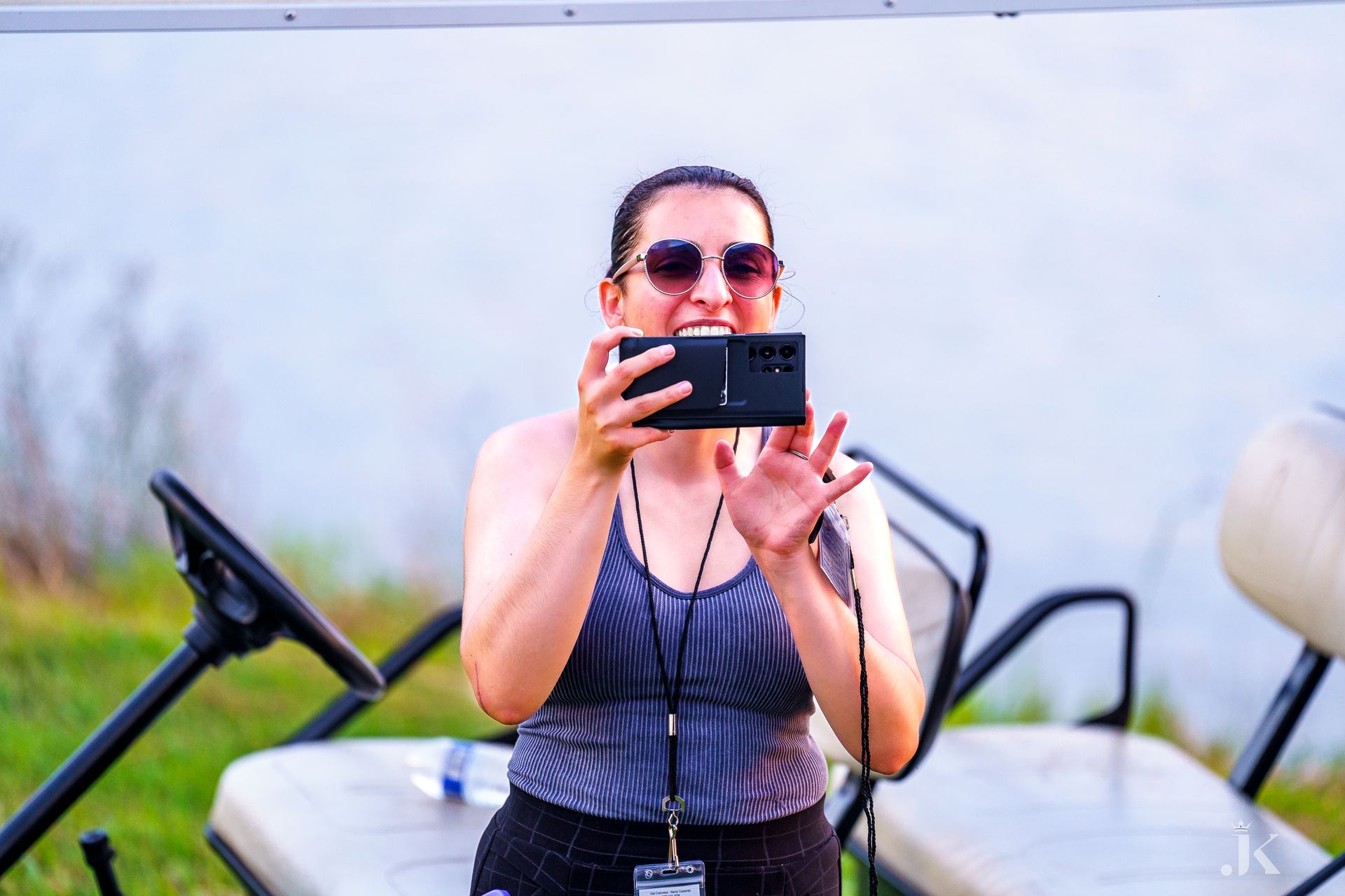 A woman is taking a picture of herself with her cell phone.