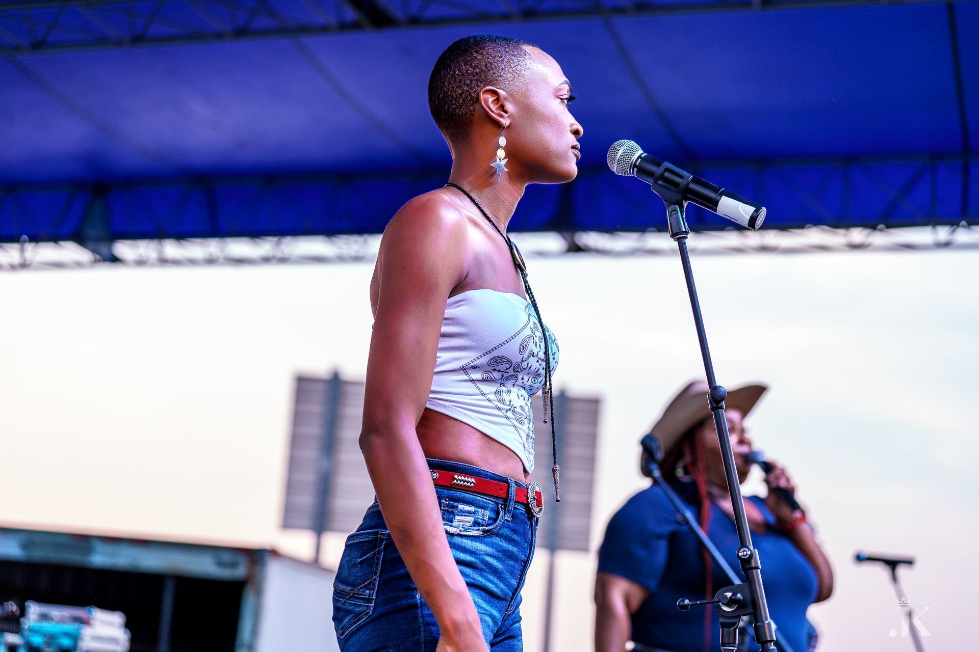 A woman is singing into a microphone on a stage.