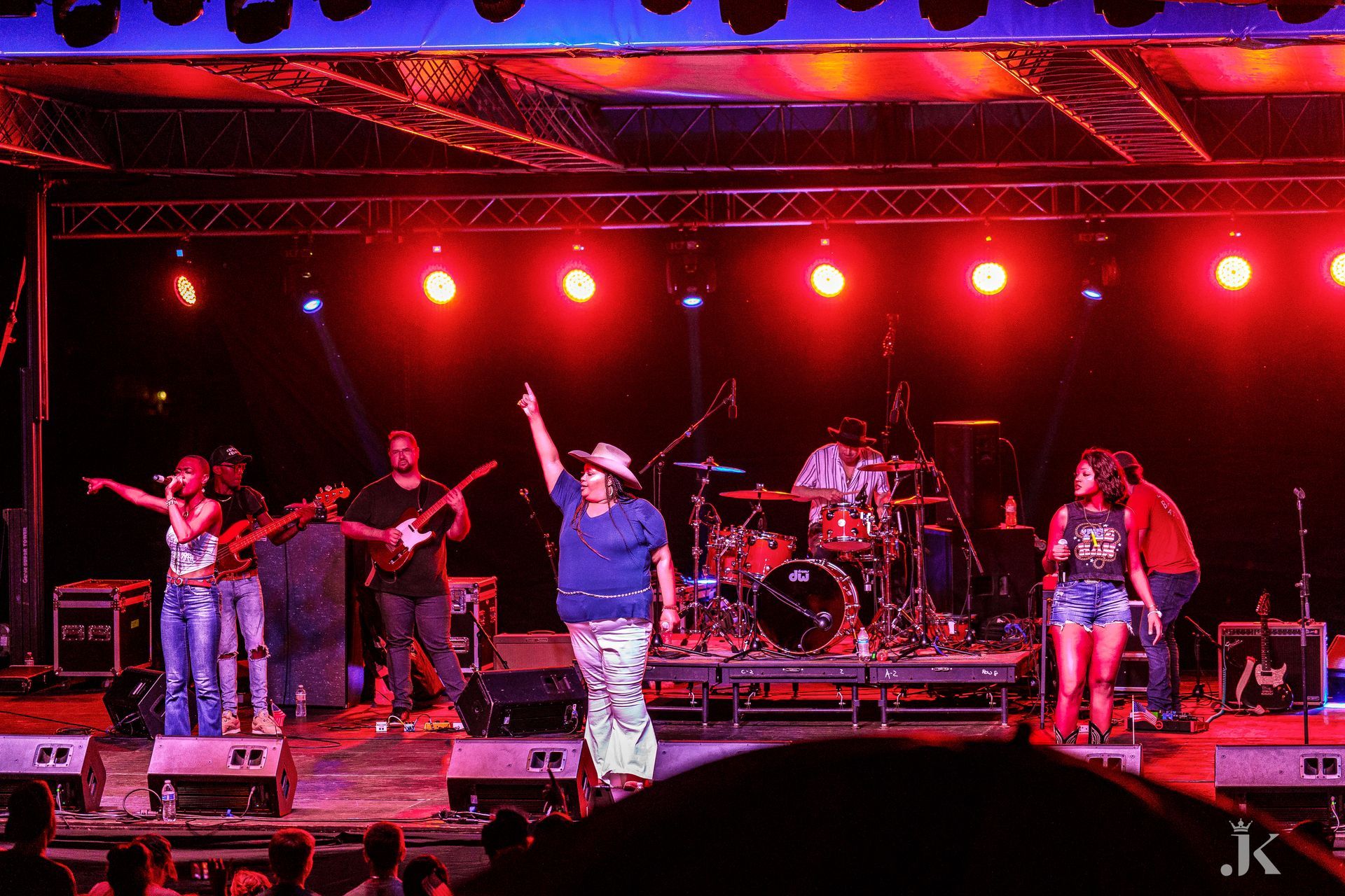A group of people are standing on a stage in front of a crowd.