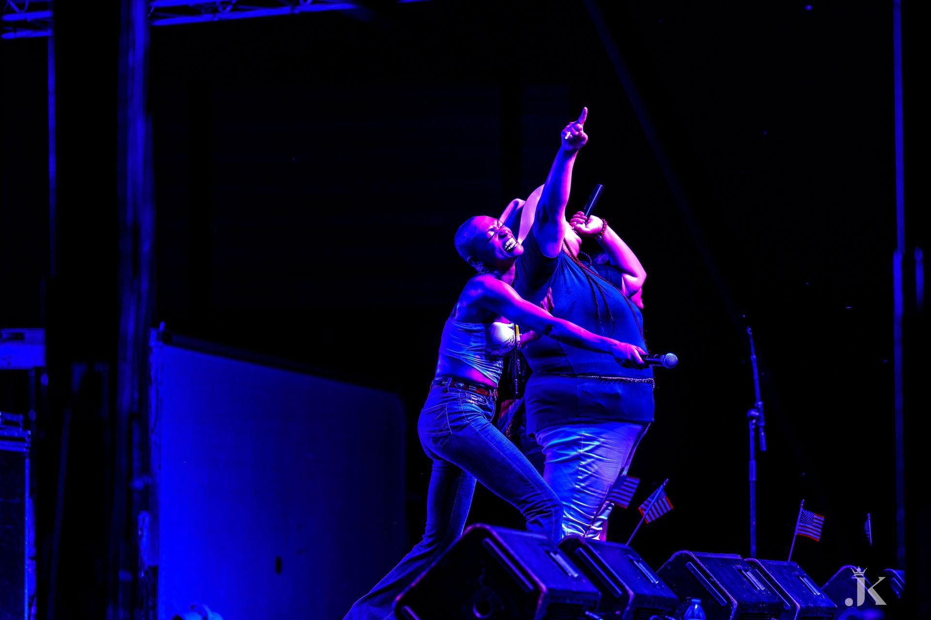 A man and a woman are singing into microphones on a stage.