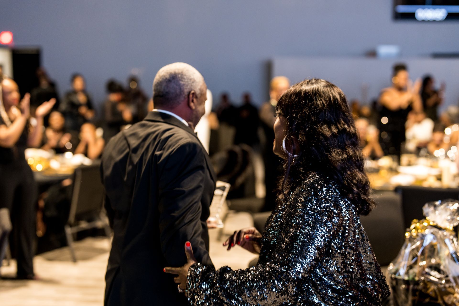 A man and a woman are dancing together at a party.