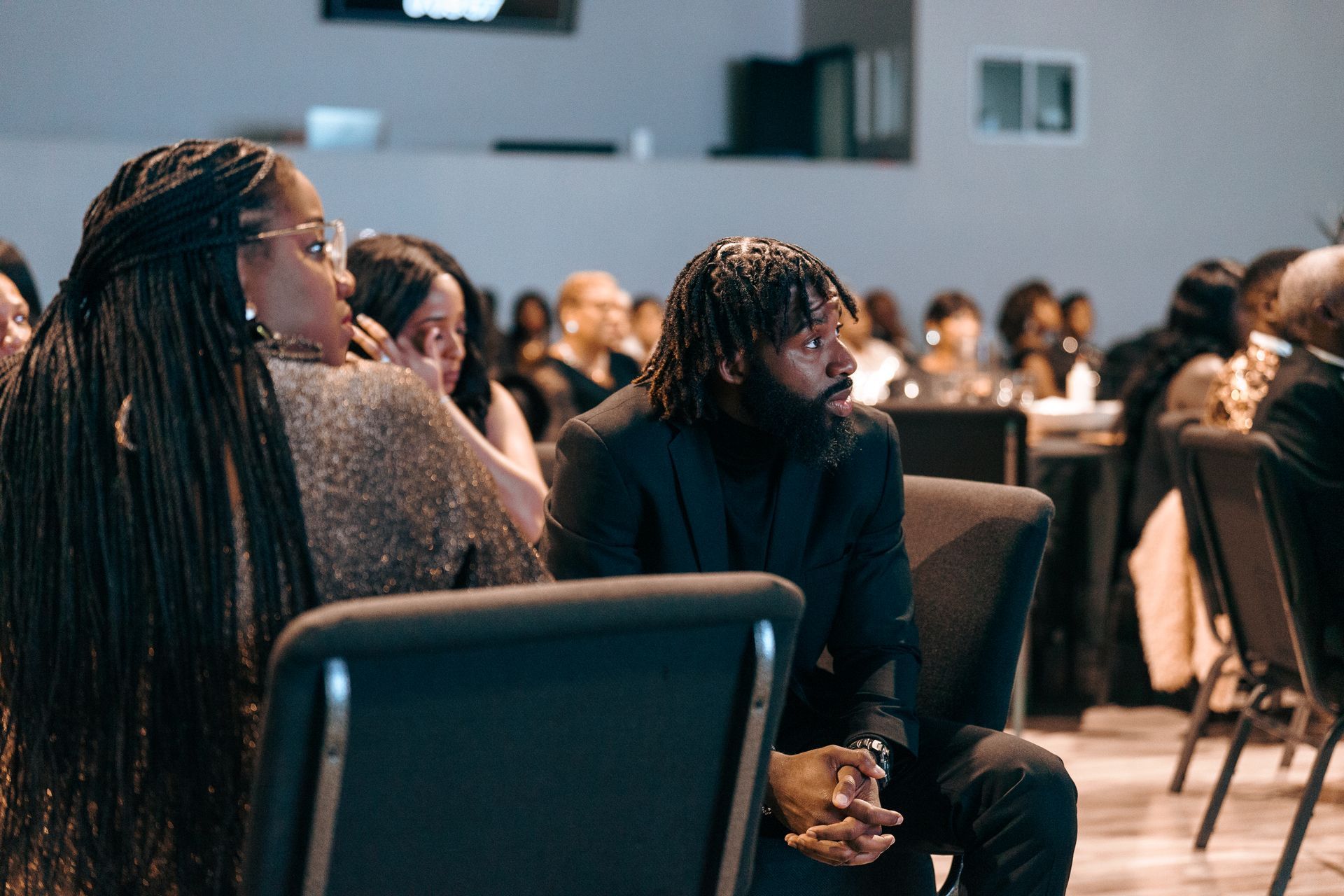 A man and a woman are sitting in chairs at a conference.