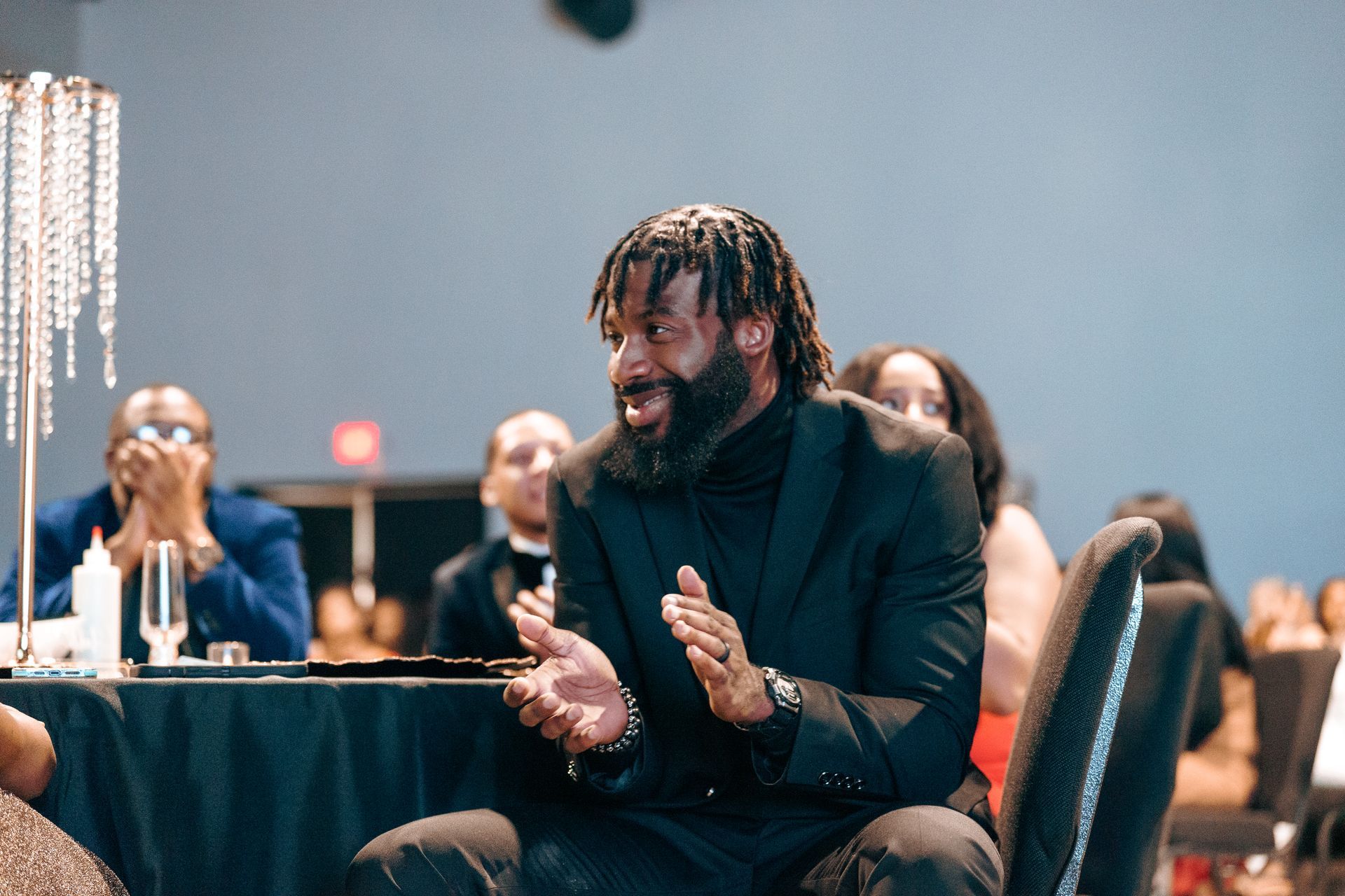 A man in a suit is sitting in a chair at a table.