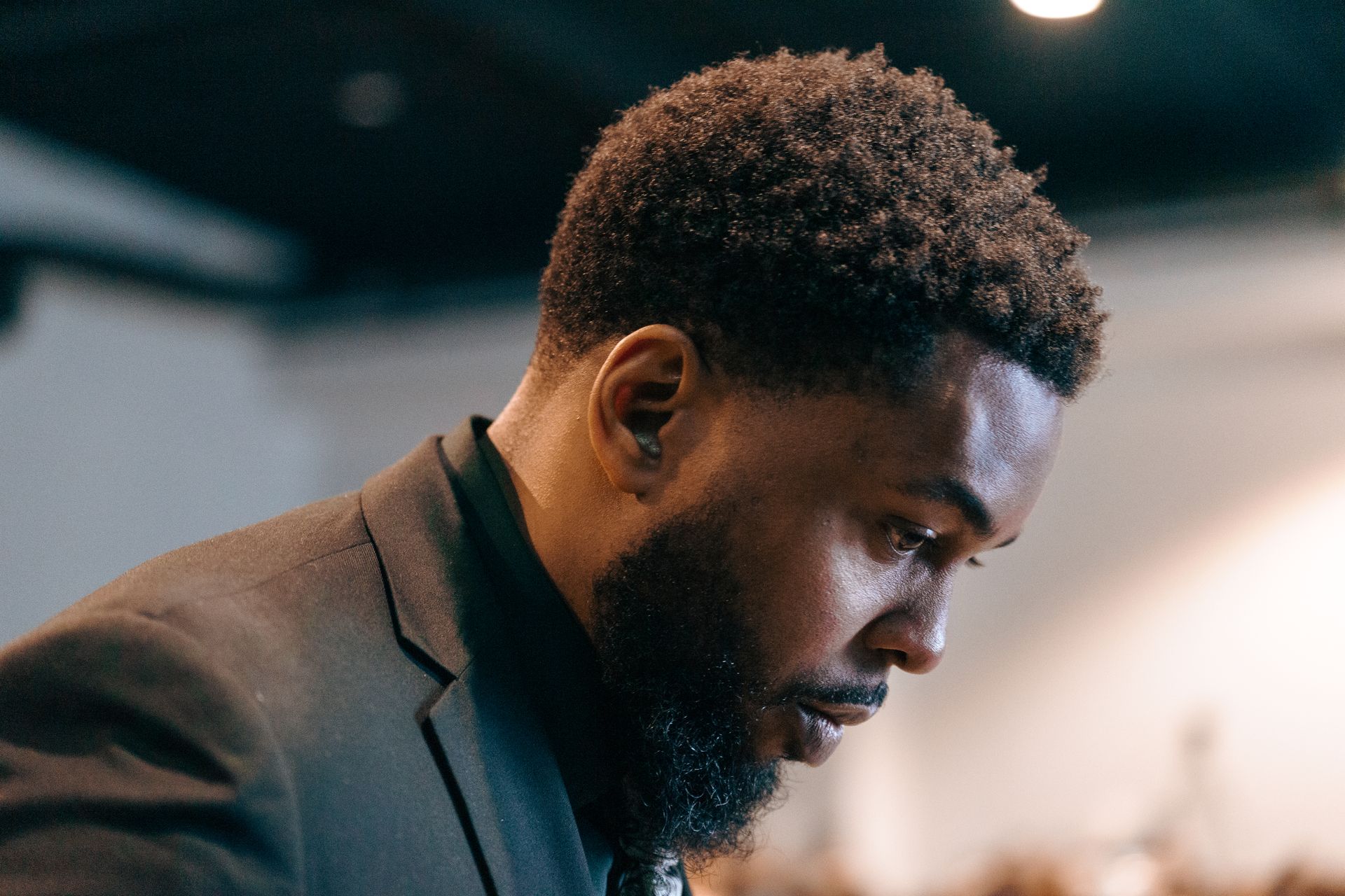 A man in a suit and tie is looking down.