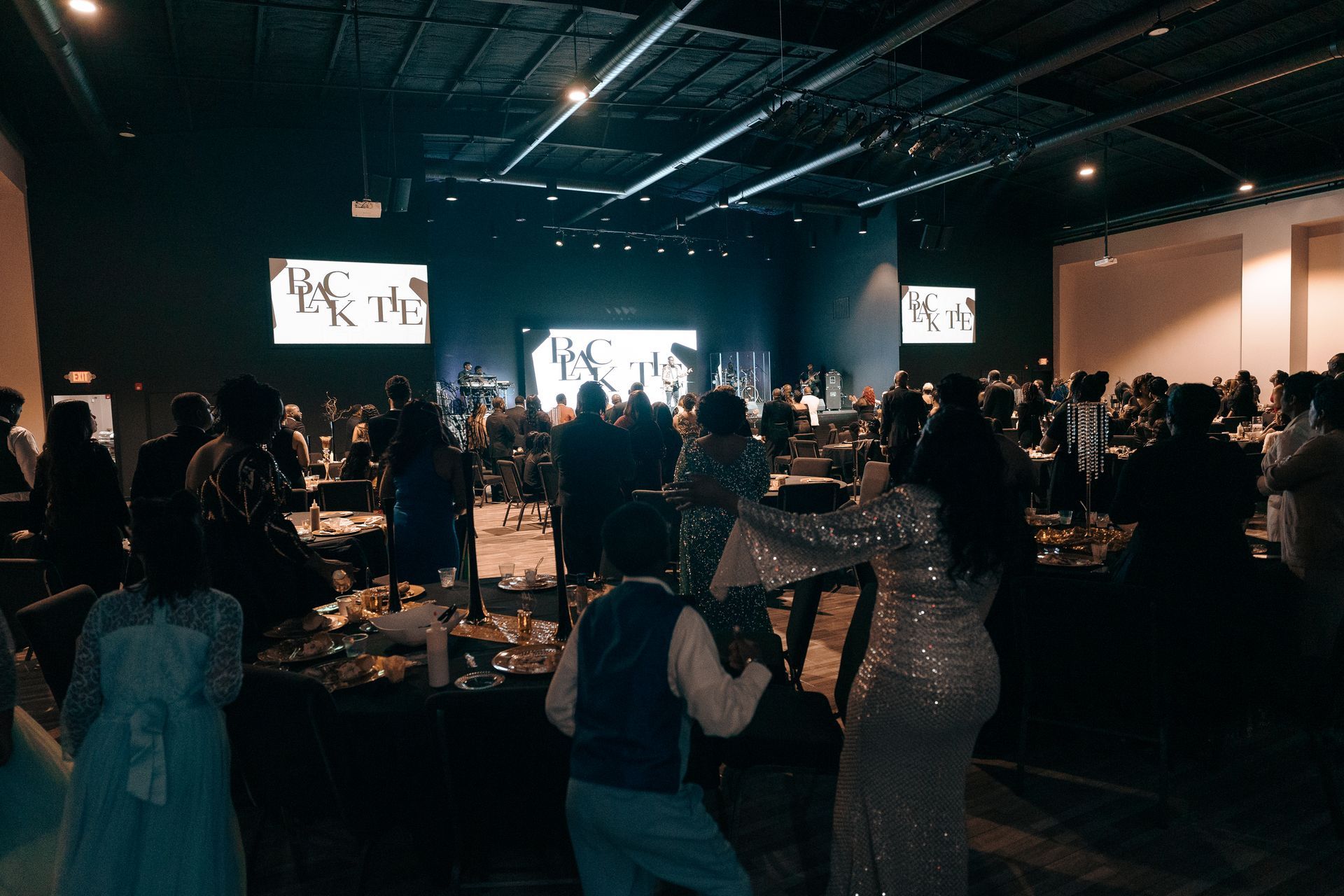 A group of people are standing in a large room.
