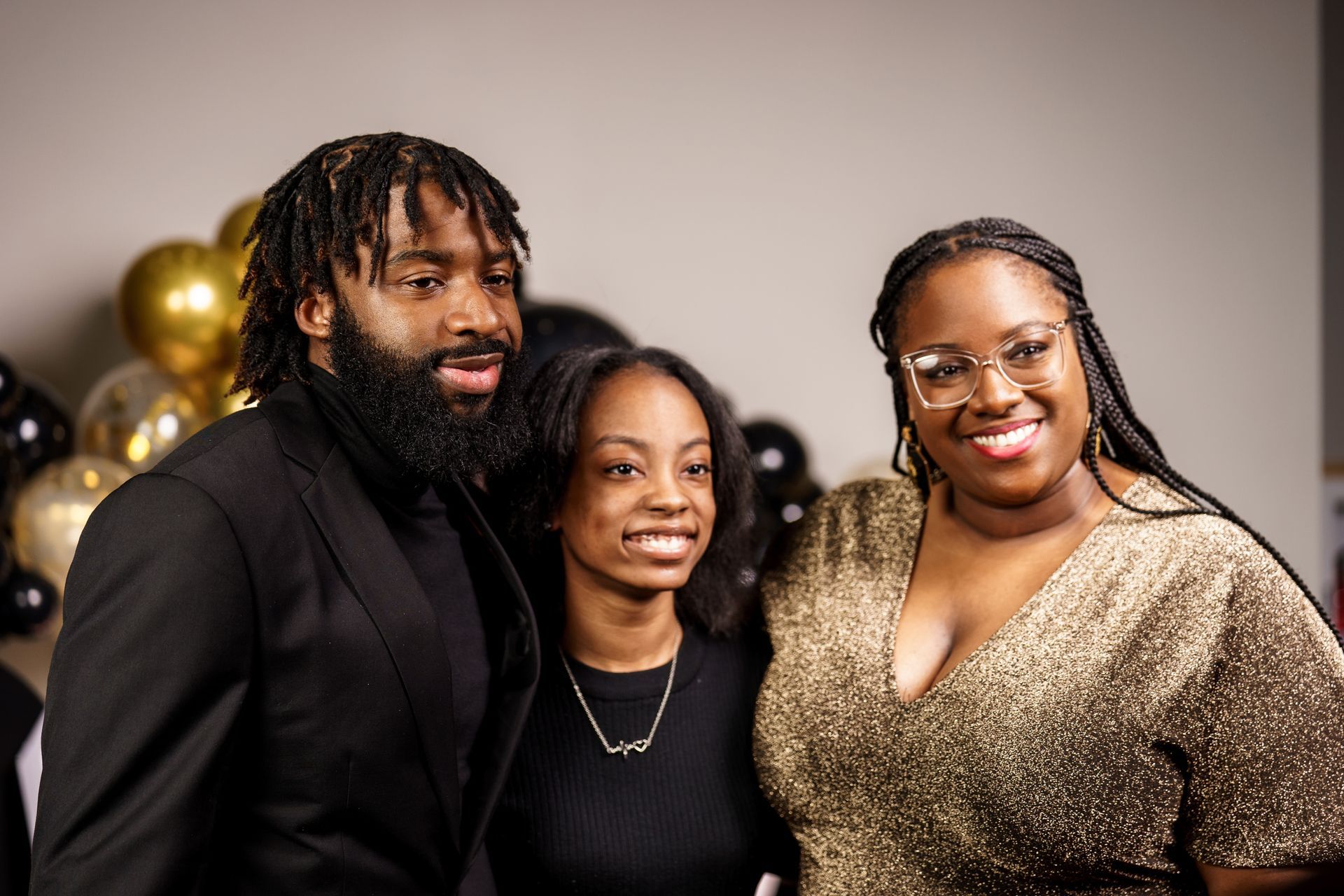A man and two women are posing for a picture together.