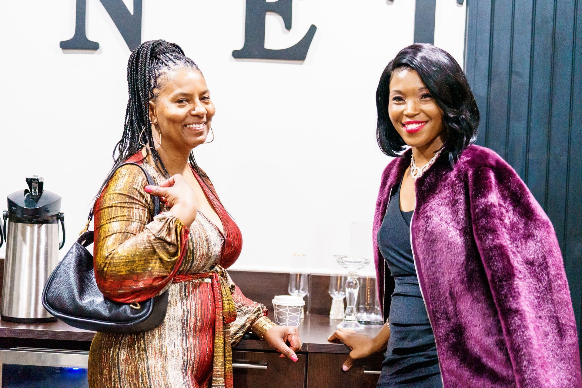 Two women are standing next to each other in a room.