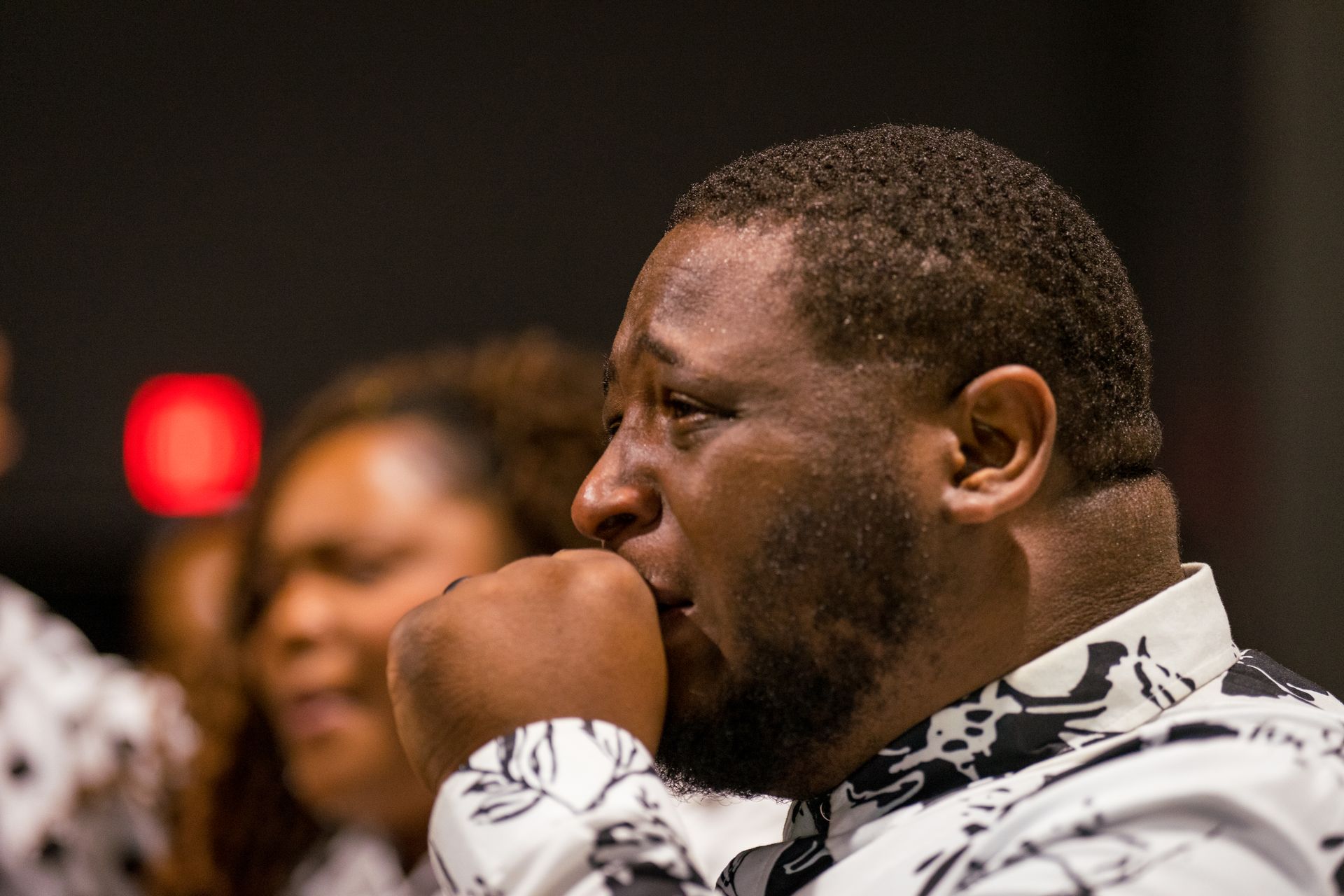 A man with a beard is sitting in front of a group of people.