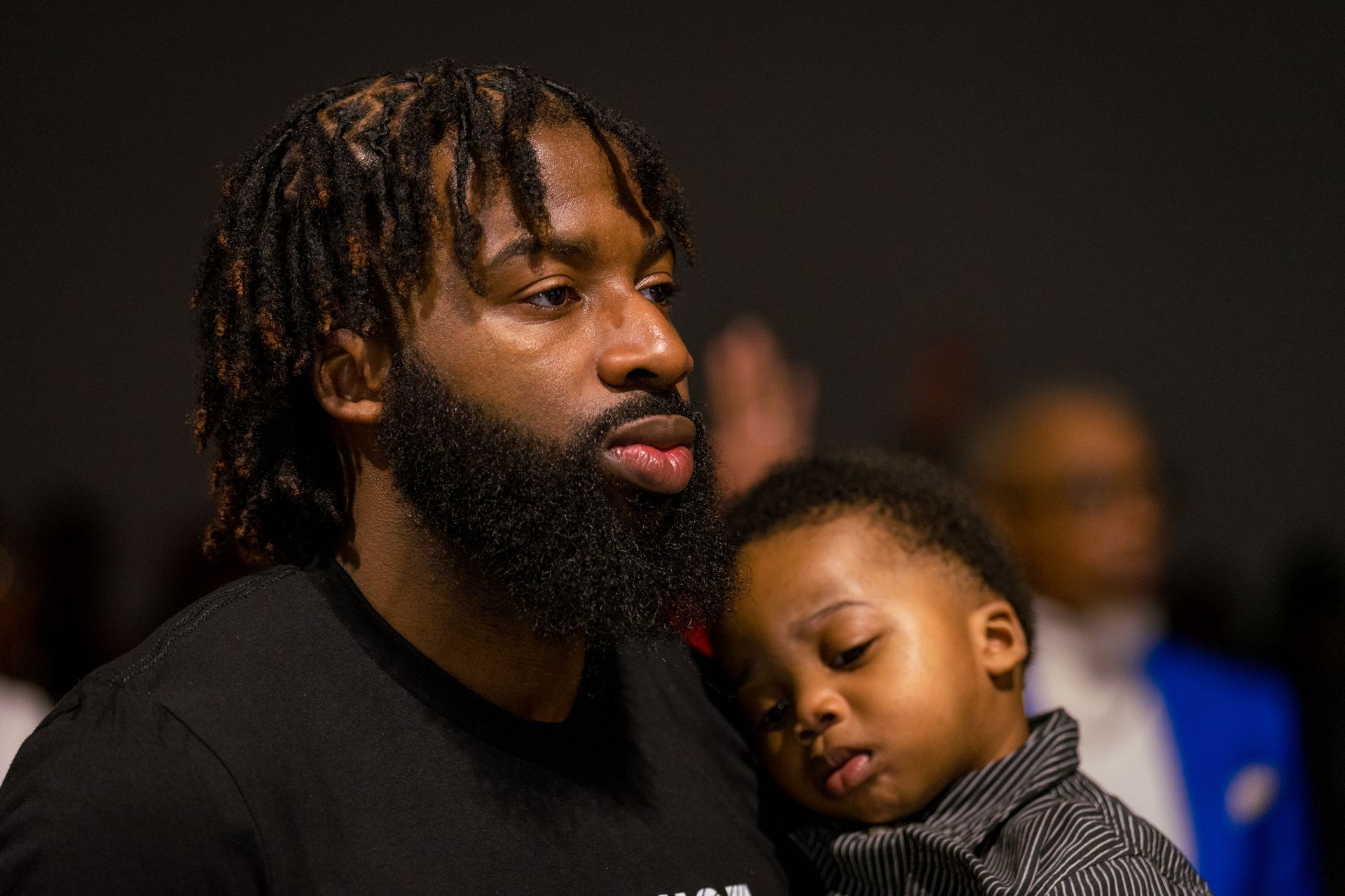 A man with a beard is holding a baby in his arms.