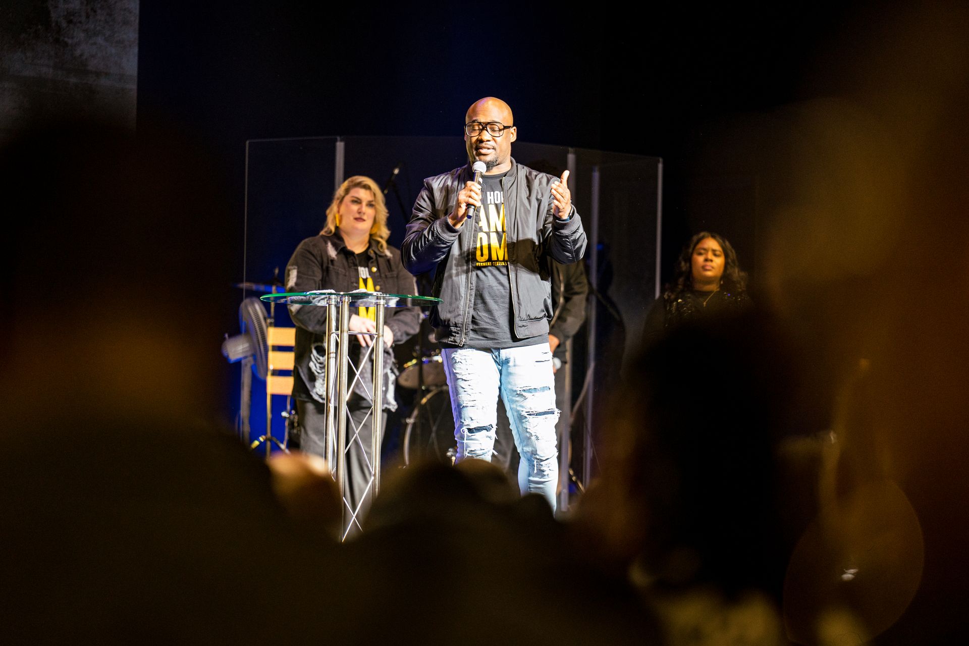 A man is standing at a podium giving a speech in front of a crowd.