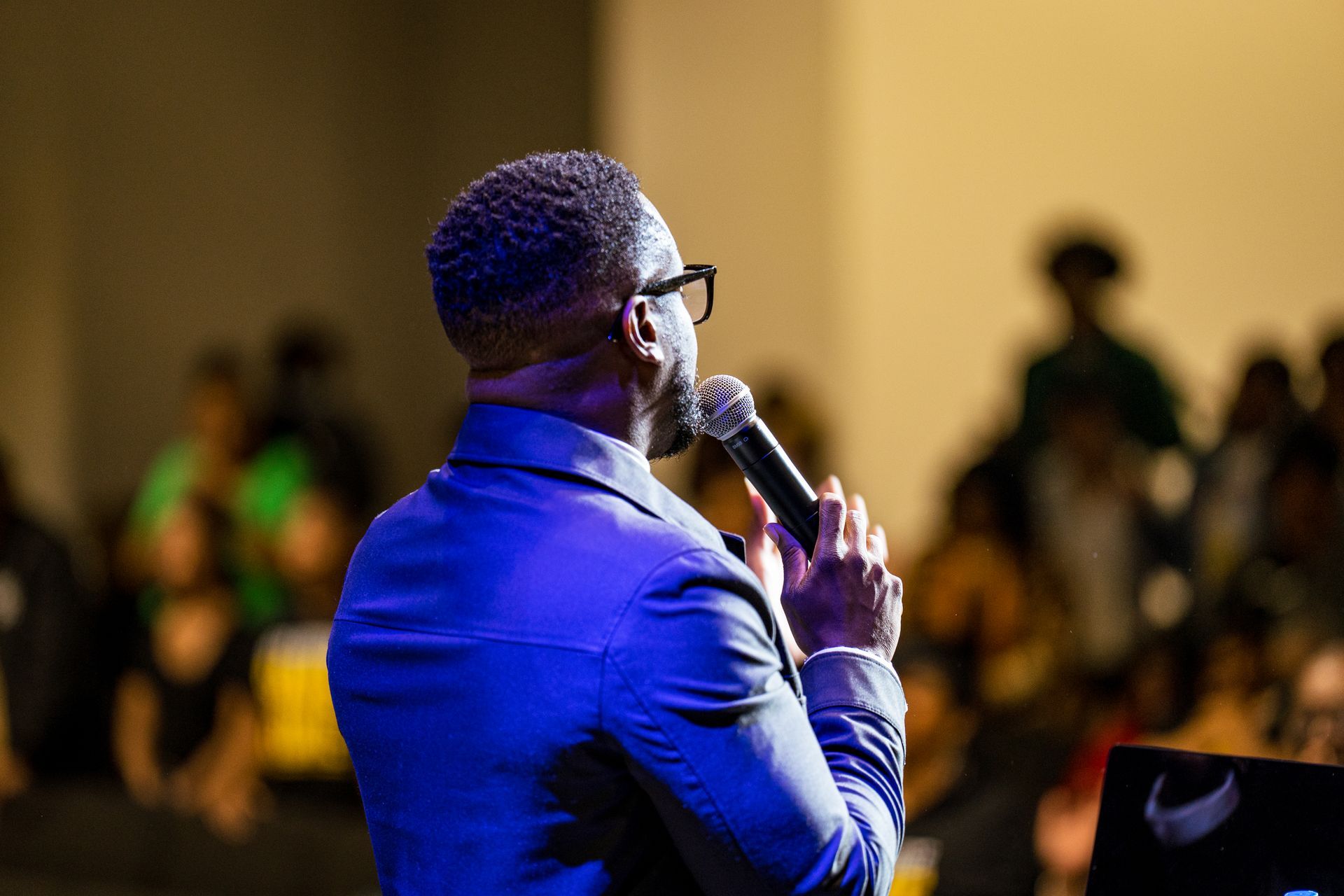 A man is holding a microphone in front of a crowd.