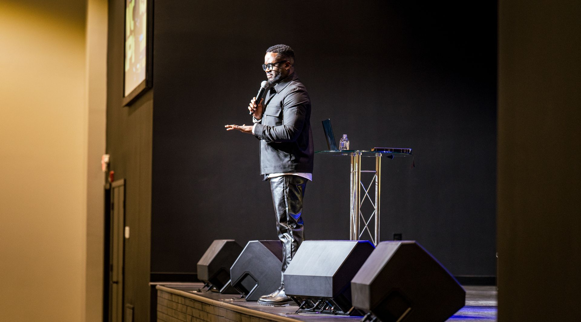 A man is standing on a stage holding a microphone.