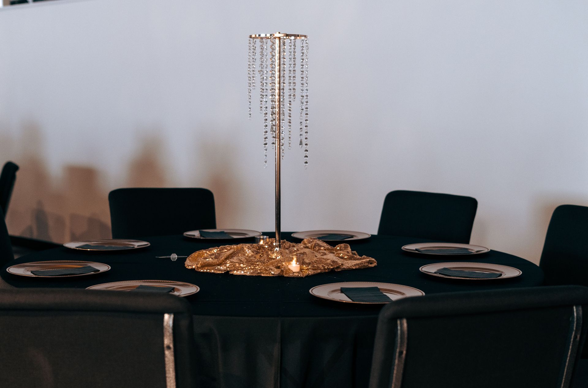 A table with plates and a gold centerpiece on it